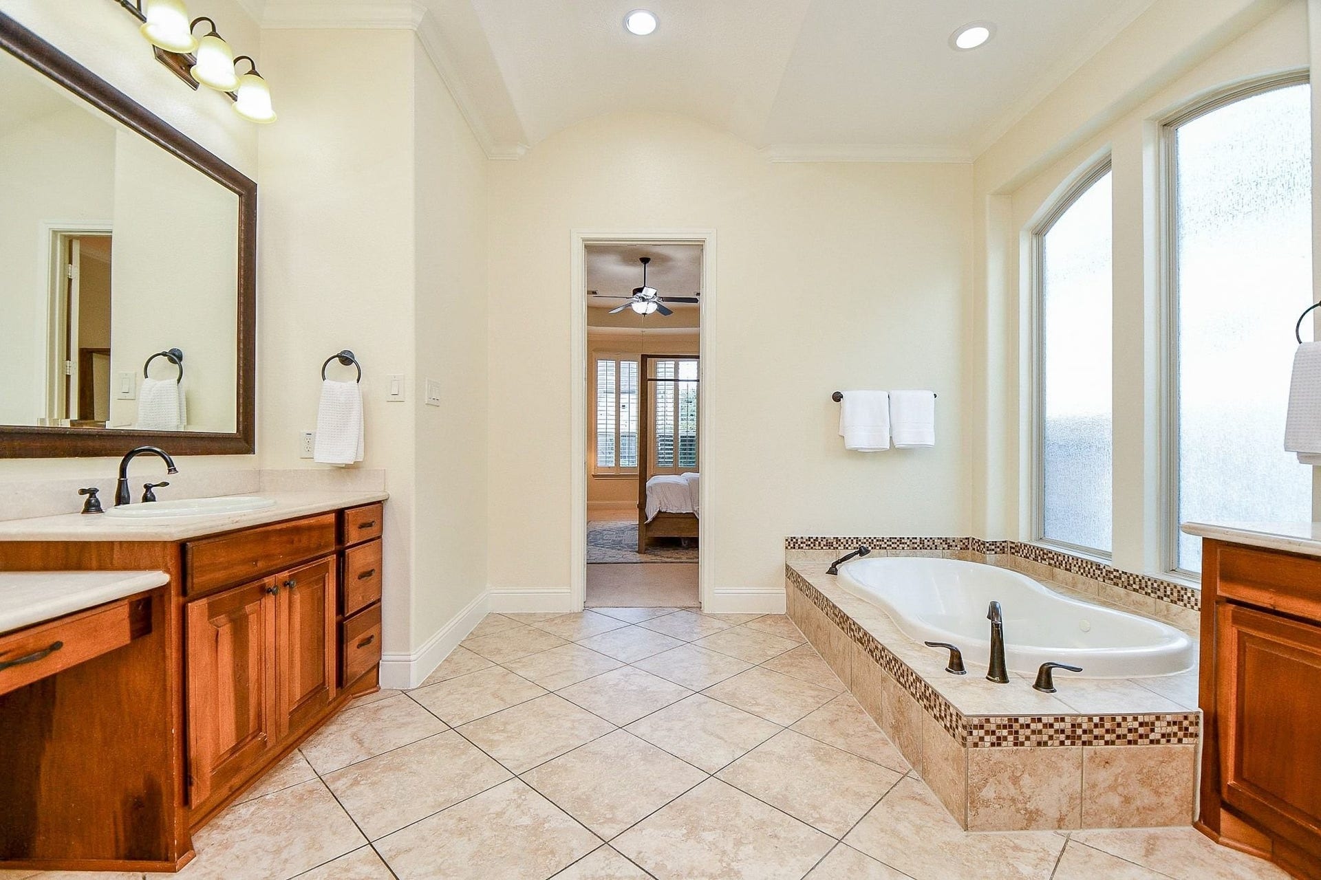 11410 Sardinia Drive, Richmond, TX 77406 From this angle, you can appreciate the spaciousness of the primary bathroom, including the seated vanity area. Extra recessed lighting and large frosted windows fill the space with light while maintaining privacy.