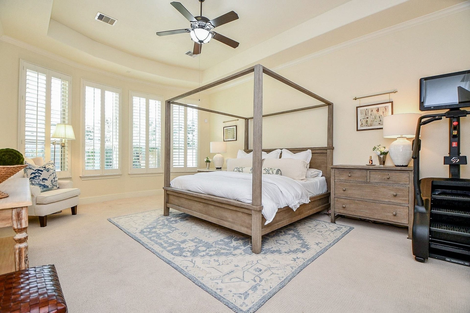 11410 Sardinia Drive, Richmond, TX 77406 The spacious primary bedroom offers beautiful bow windows adorned with plantation shutters, while the elegant, curved tray ceiling adds architectural character, warmth, and charm to this inviting retreat.