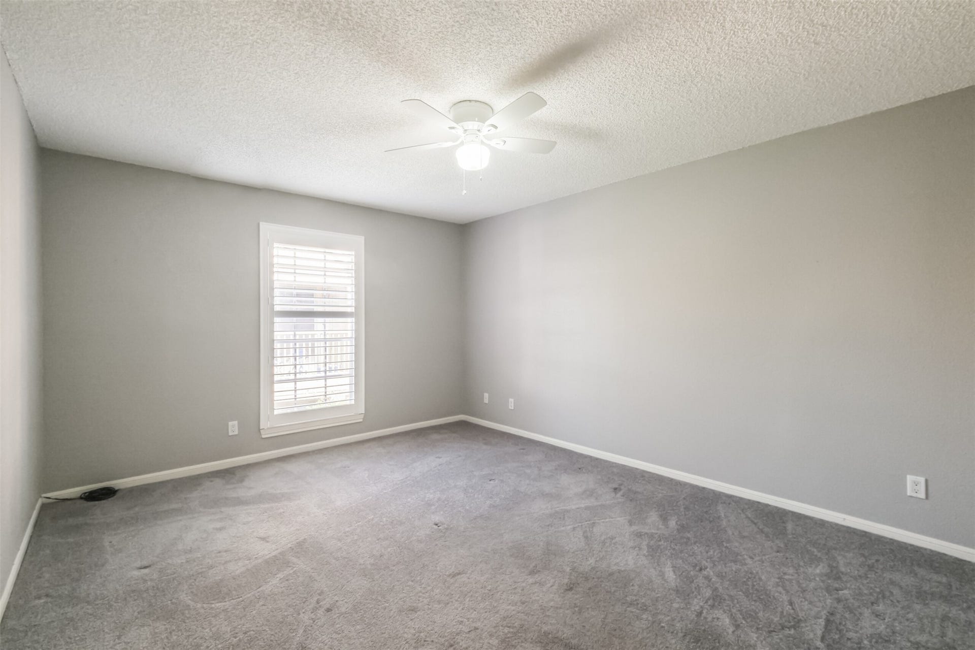 3100 Jeanetta Street, #1204, Houston, TX 77063 Spacious primary bedroom with carpeted floors and a ceiling fan!