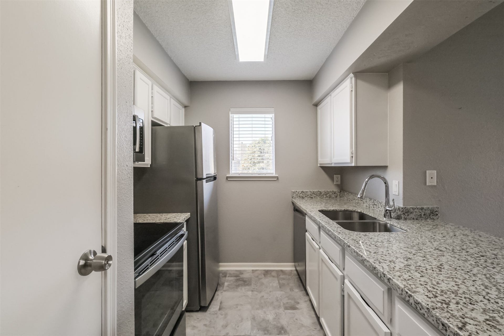 3100 Jeanetta Street, #1204, Houston, TX 77063 Updated kitchen featuring granite countertops, stainless steel appliances including a refrigerator, and plenty of cabinet storage!