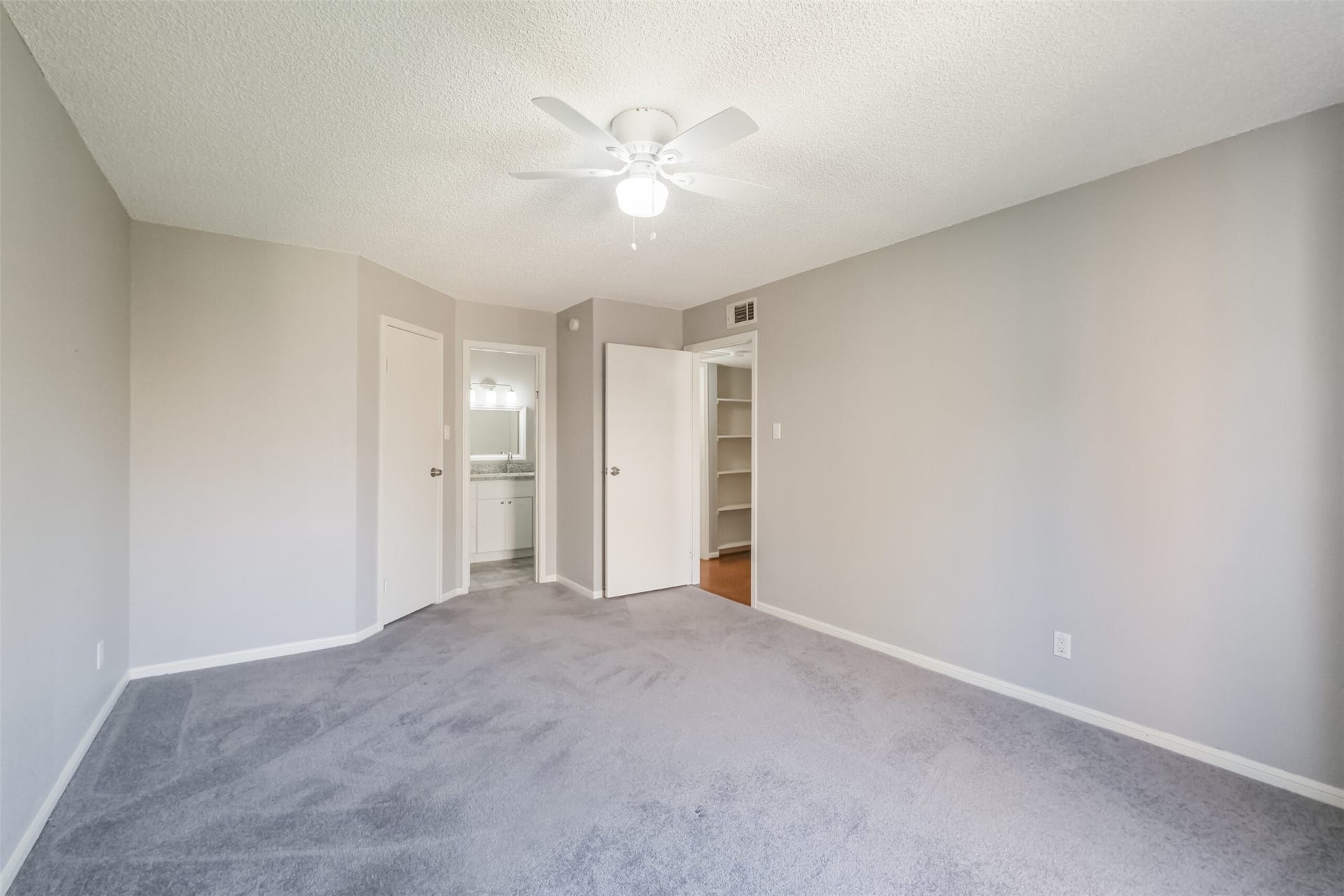 3100 Jeanetta Street, #1204, Houston, TX 77063 Spacious primary bedroom with carpeted floors and a ceiling fan!