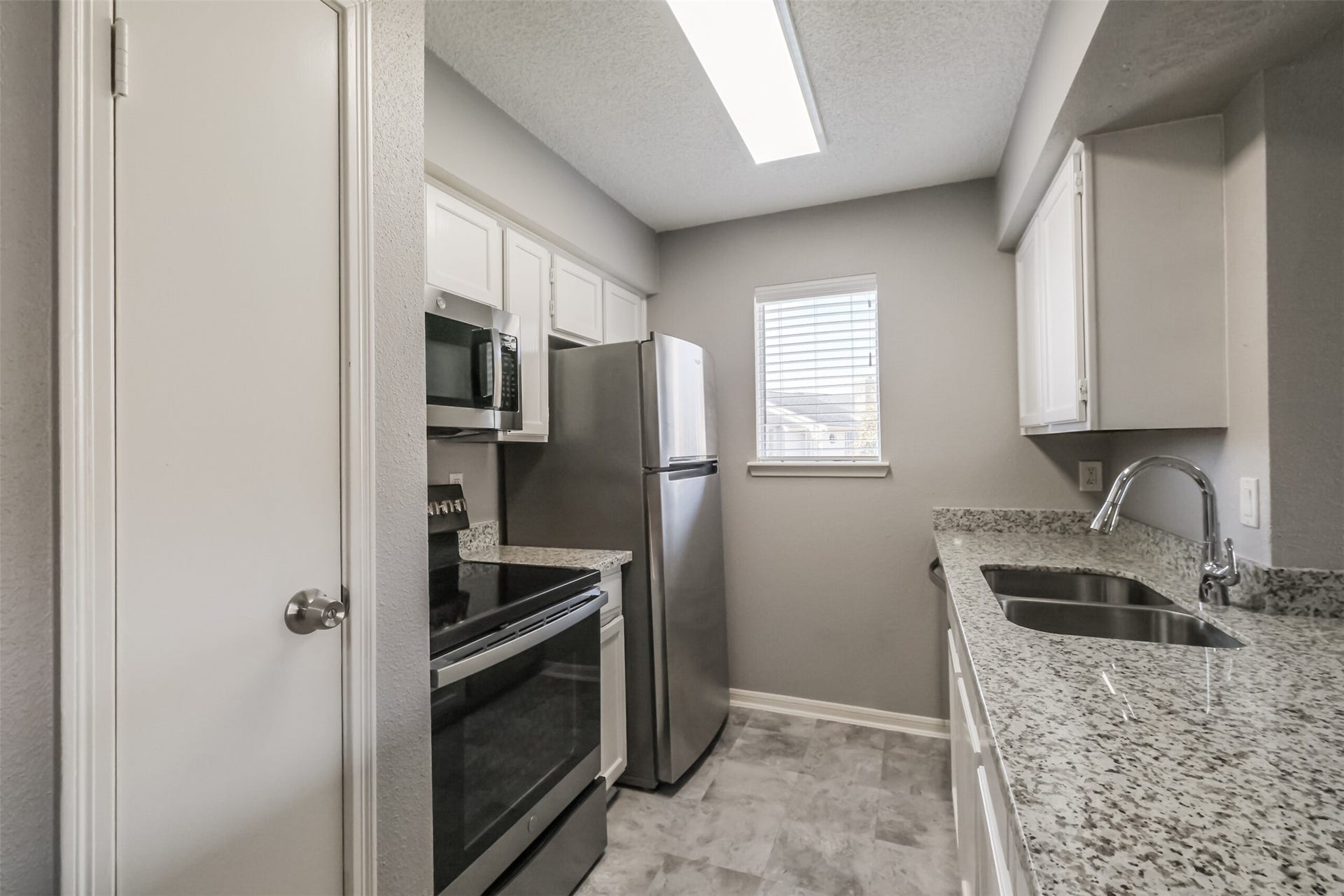 3100 Jeanetta Street, #1204, Houston, TX 77063 Updated kitchen featuring granite countertops, stainless steel appliances including a refrigerator, and plenty of cabinet storage!