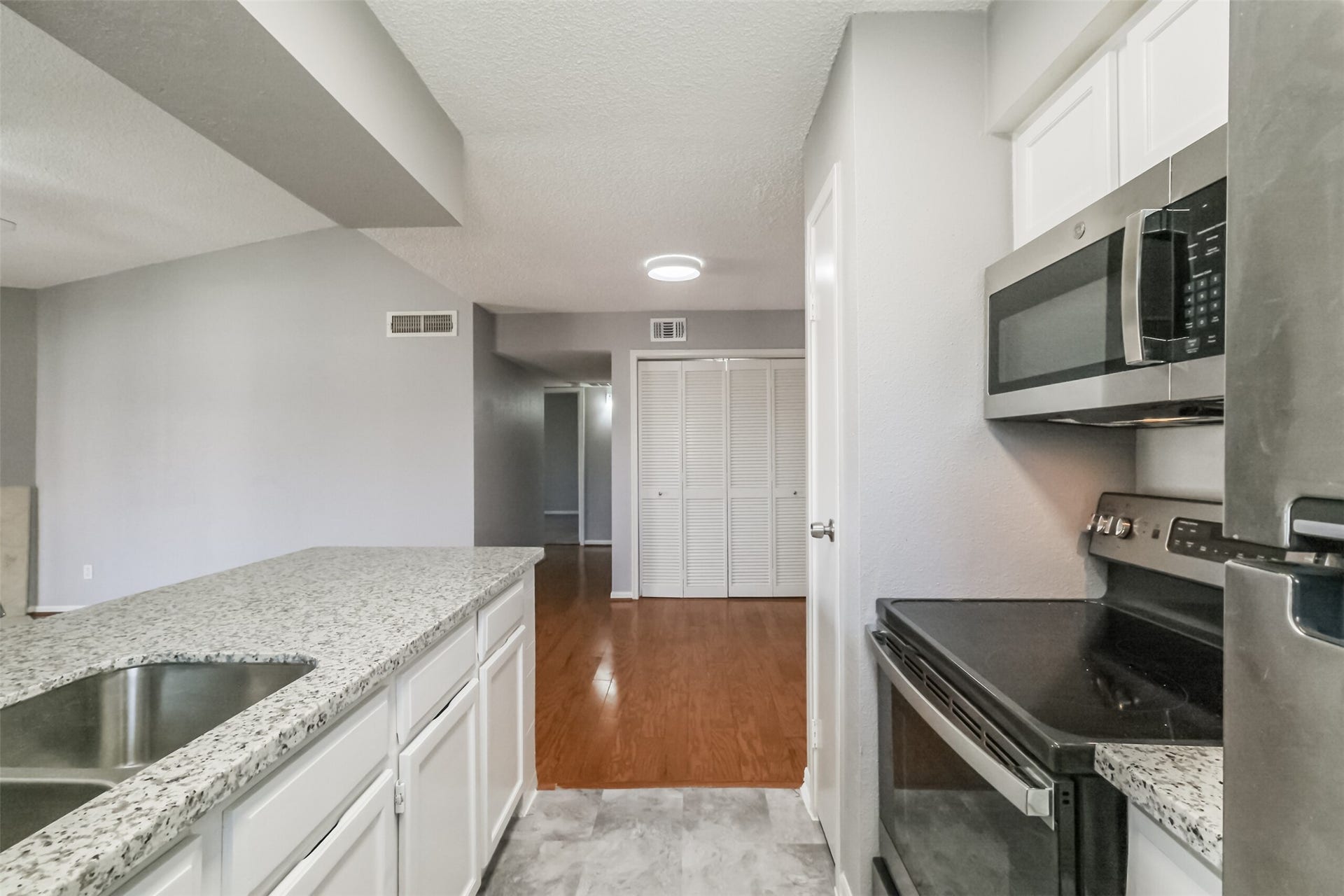3100 Jeanetta Street, #1204, Houston, TX 77063 Updated kitchen featuring granite countertops, stainless steel appliances including a refrigerator, and plenty of cabinet storage!