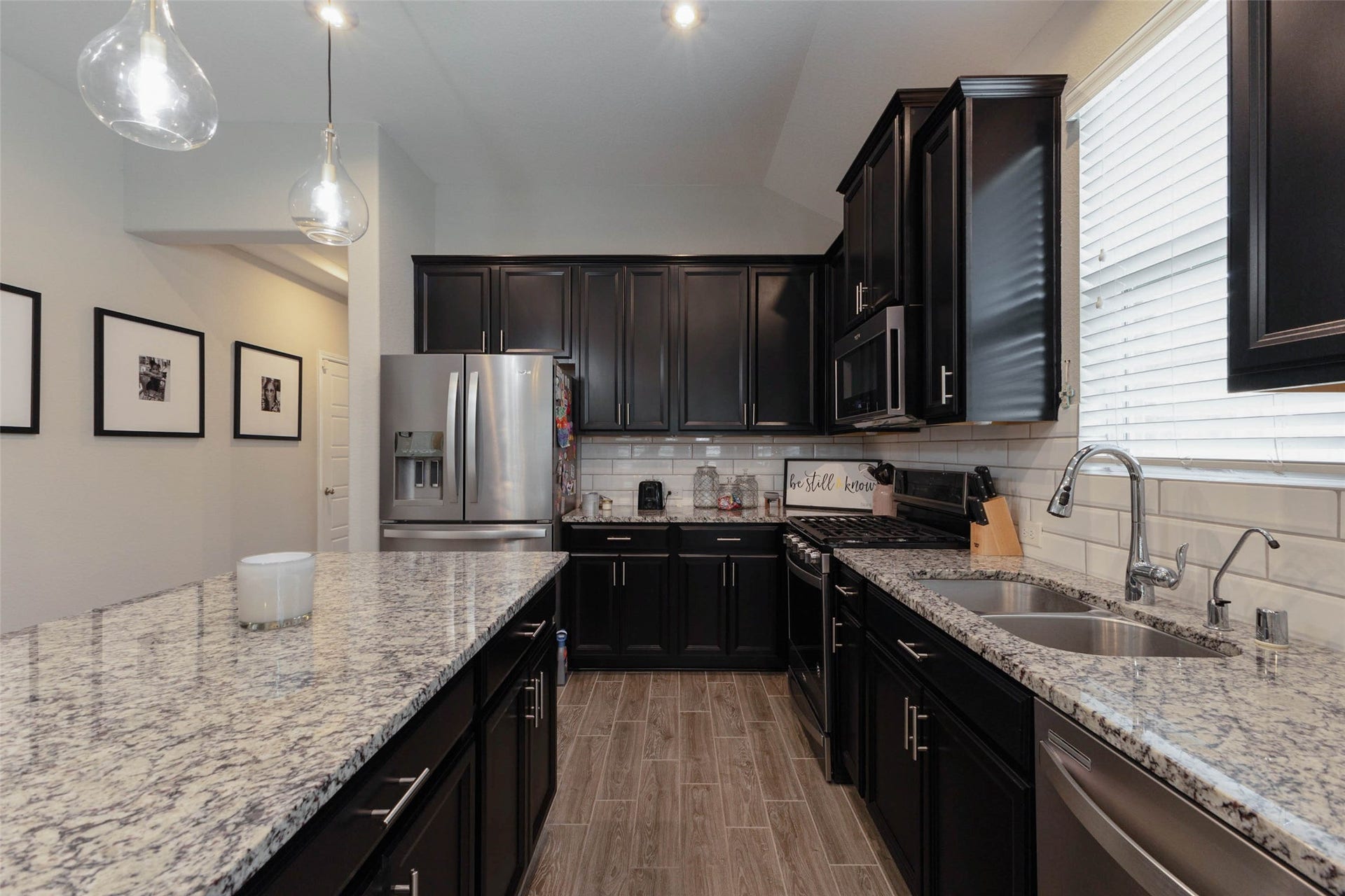 Additional kitchen view highlighting granite countertops, ample cabinet storage, stainless steel appliances, and a functional layout.
