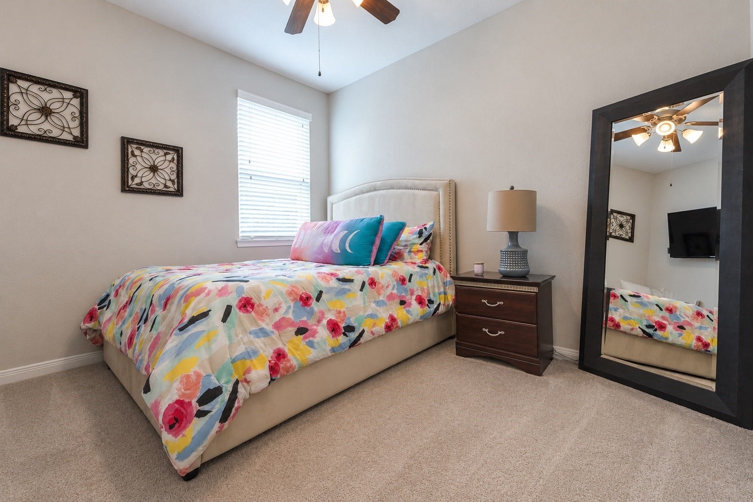 Additional secondary bedroom offering neutral wall tones, a ceiling fan, and a spacious closet.