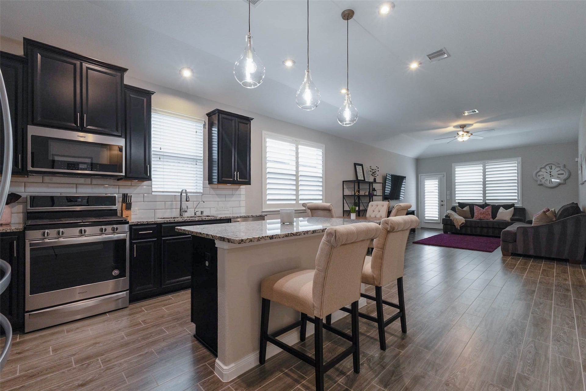 Spacious open-concept kitchen and dining area featuring a large center island, pendant lighting, and seamless flow into the living room.