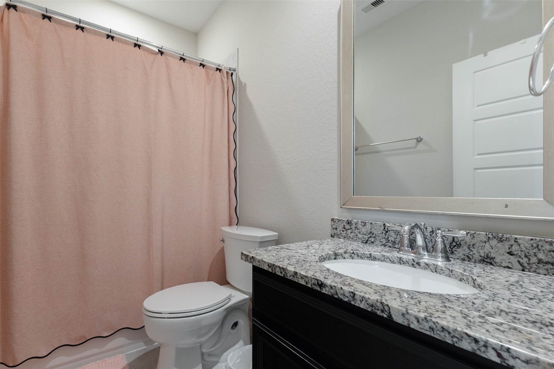 Secondary bathroom featuring a granite countertop vanity, decorative backsplash, and tub/shower combination.