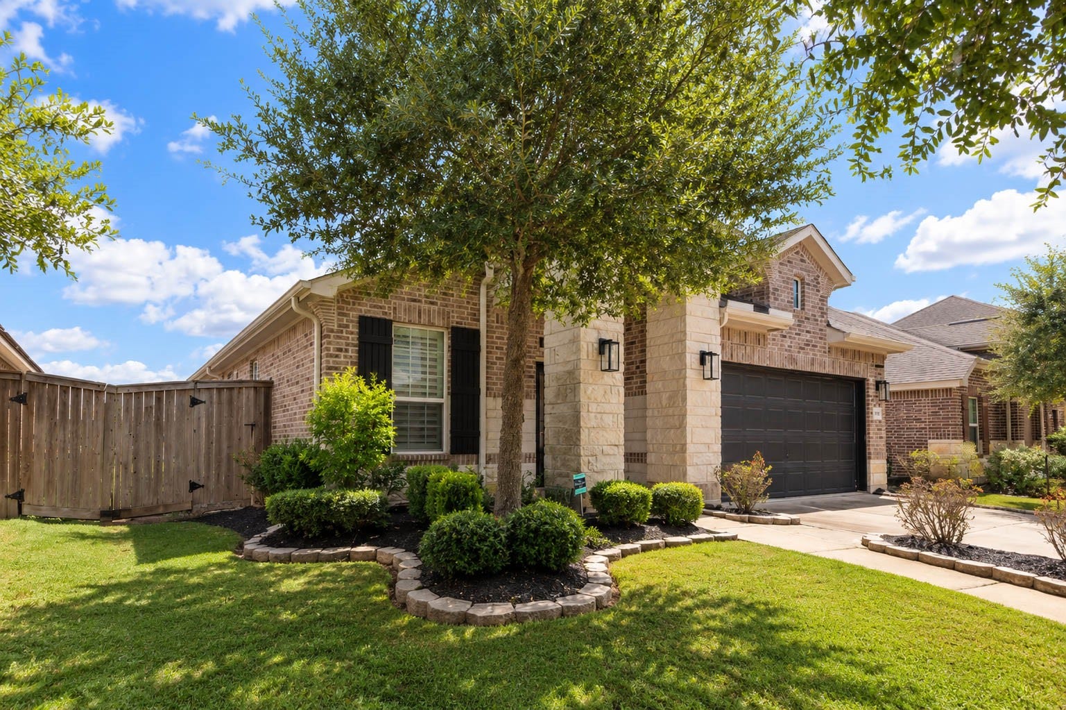 Beautifully maintained front landscaping complements the home's inviting covered entry and architectural details.