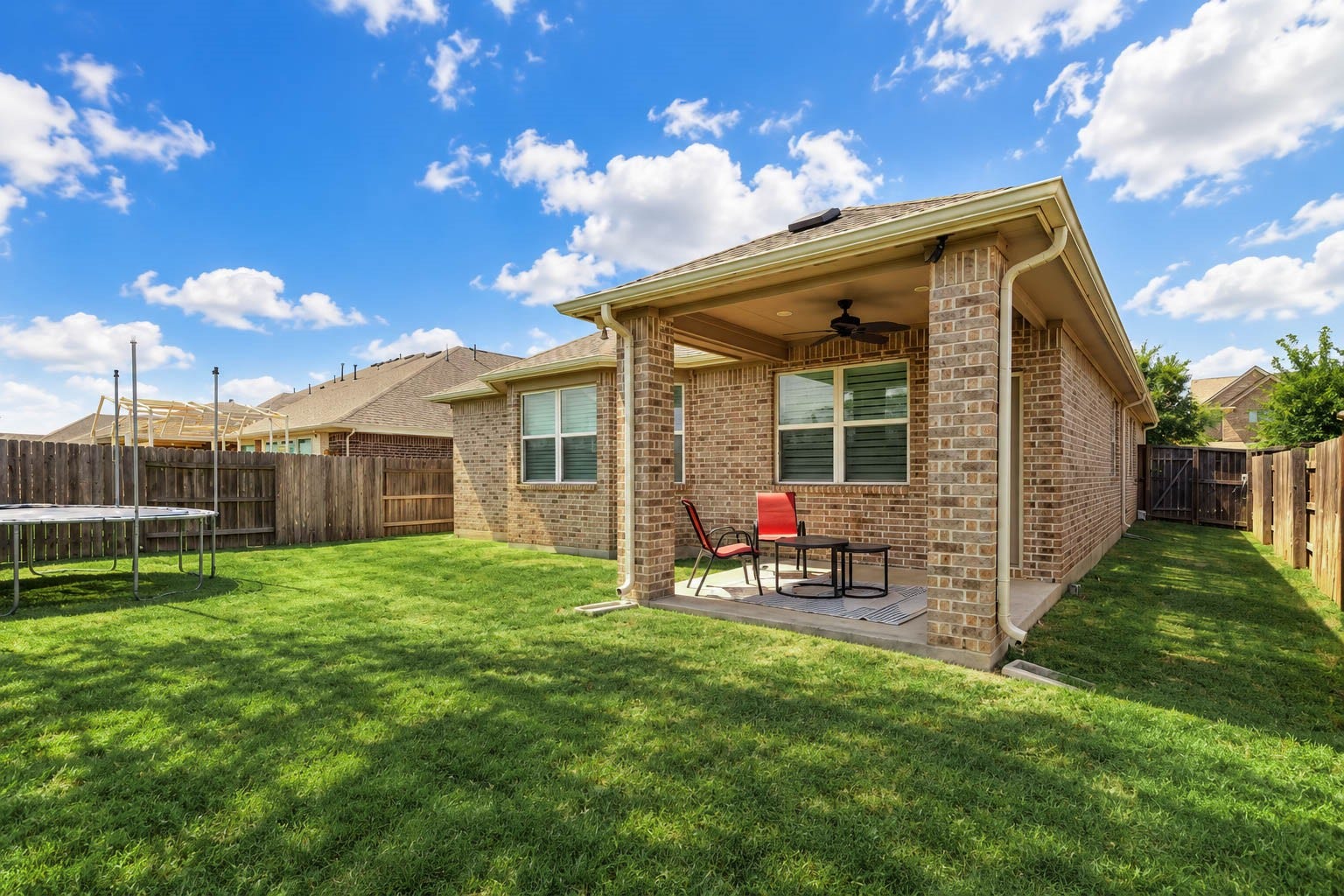 Additional backyard perspective showcasing the covered patio, landscaped yard, and room for outdoor entertaining.