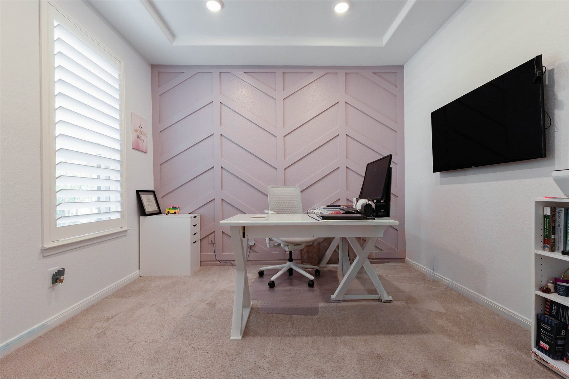 Versatile flex room featuring a tray ceiling, decorative accent wall, and natural lightideal for a home office, media room, or additional living space.