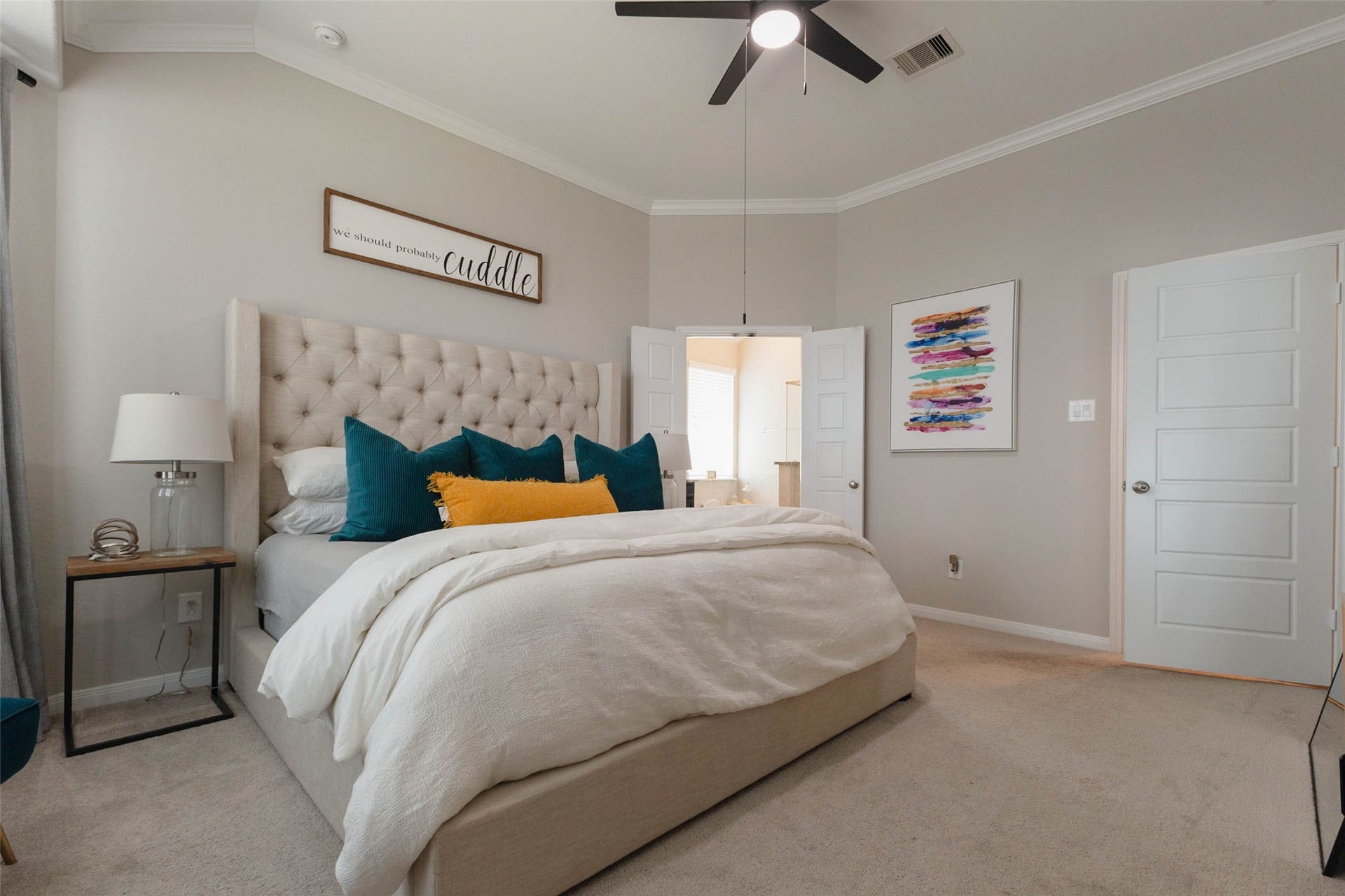 Another view of the primary suite showcasing generous floor space, a ceiling fan, and a relaxing atmosphere.