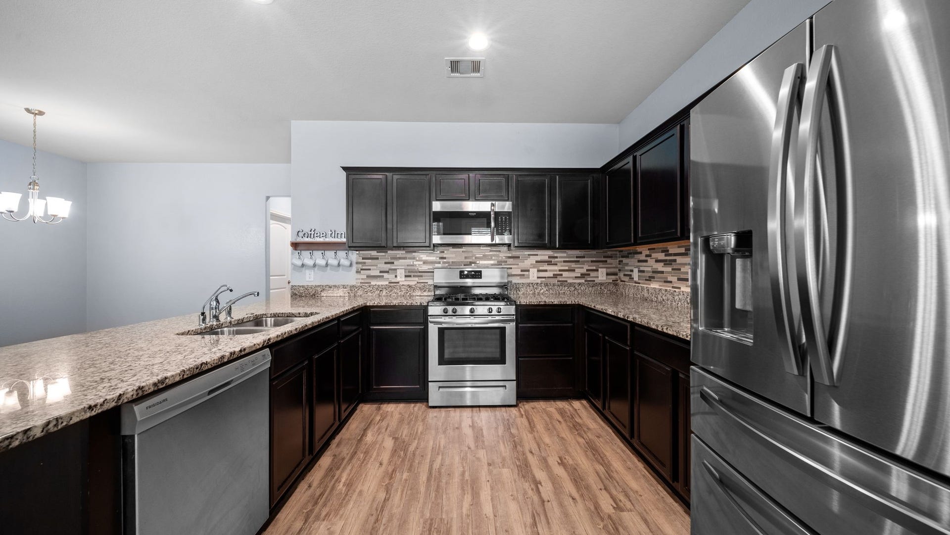 11502 Castle Nugent Court, Conroe, TX 77304 Beautifully equipped kitchen includes a French-door refrigerator, built-in microwave, and dishwasher for everyday convenience.