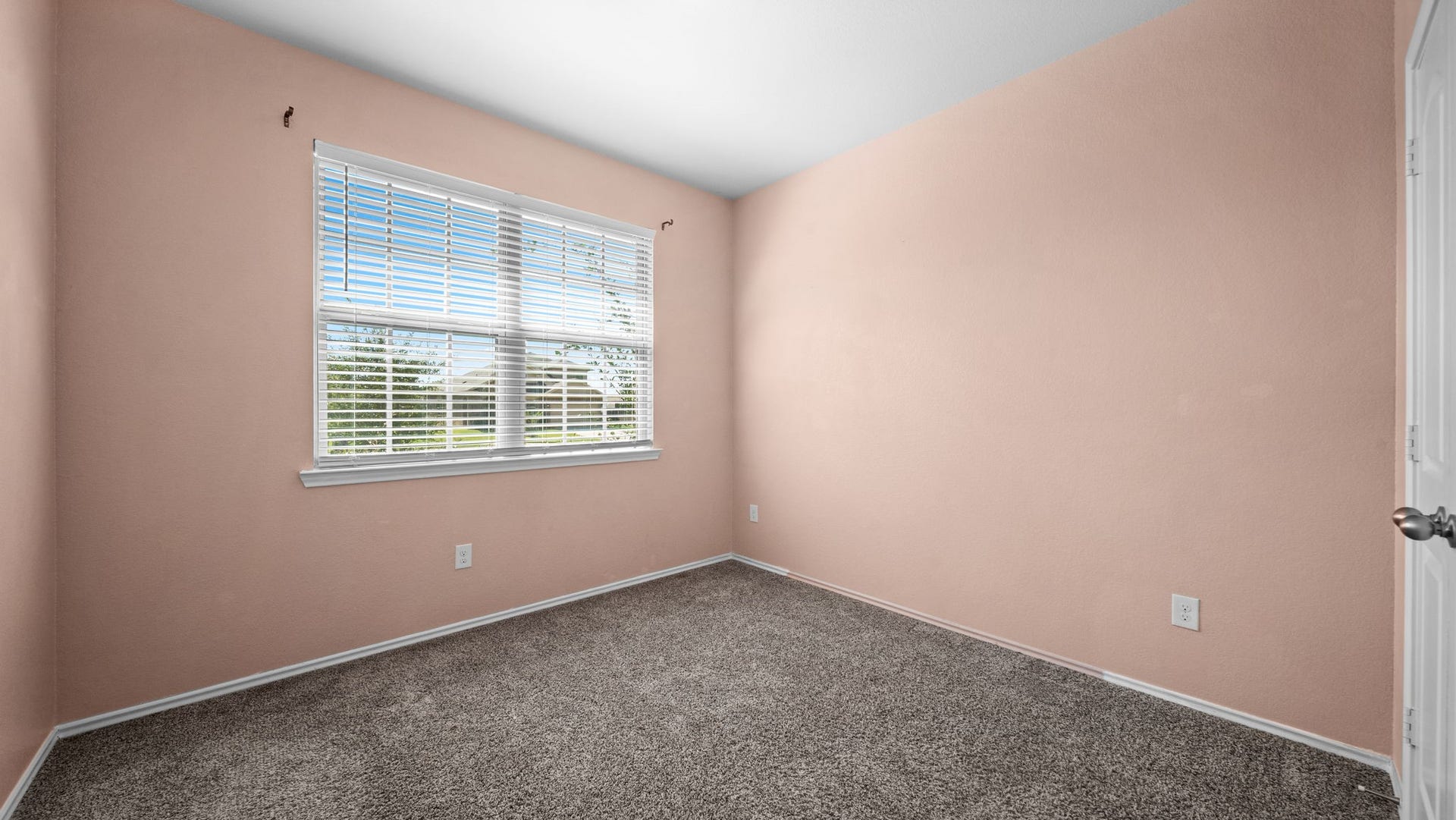 11502 Castle Nugent Court, Conroe, TX 77304 Versatile secondary bedroom with carpeting and window blinds, ideal for a variety of furniture arrangements.