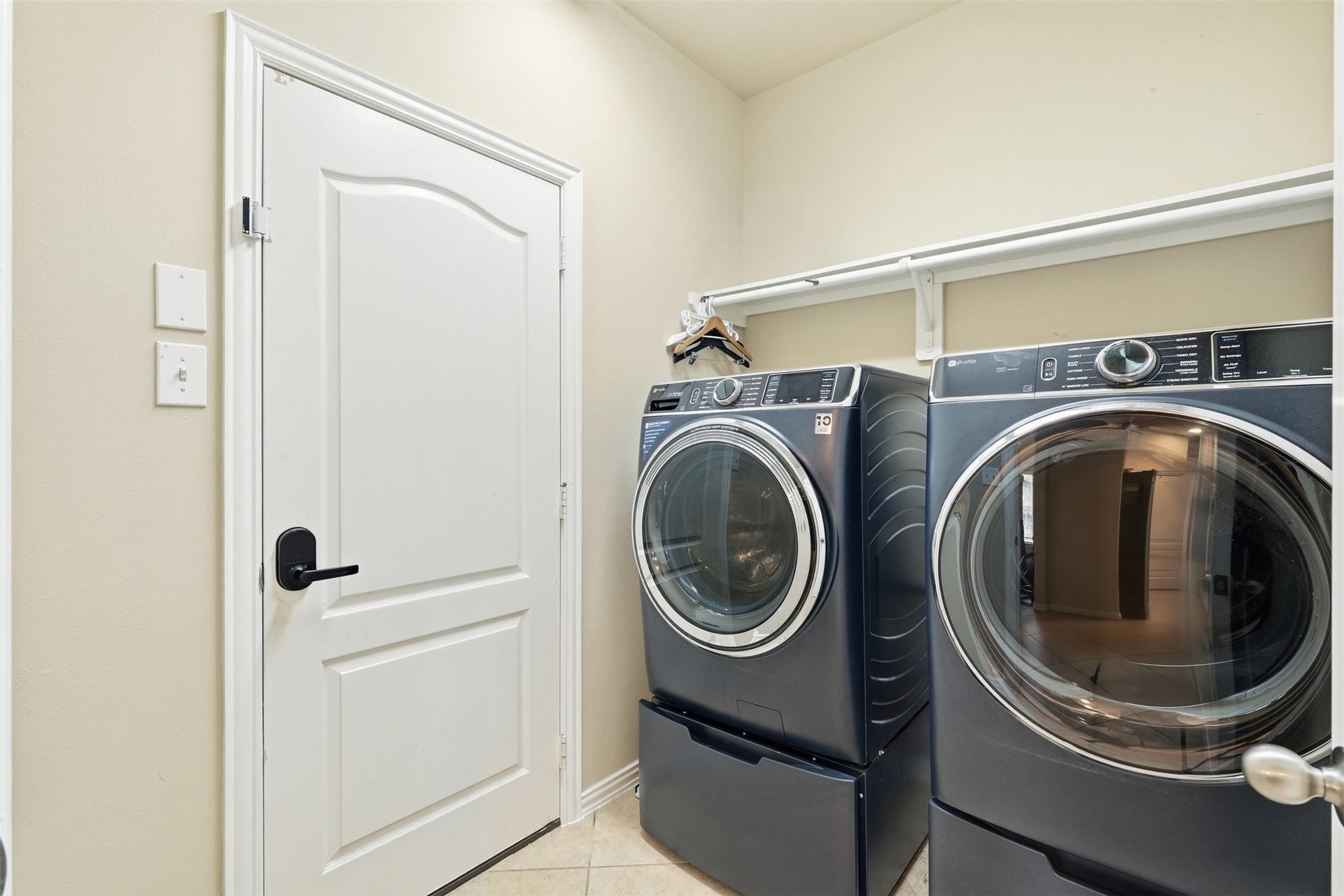 Laundry day, upgraded: a dedicated utility room with tile floors, a hanging rod and a shelf. Washer and dryer included.