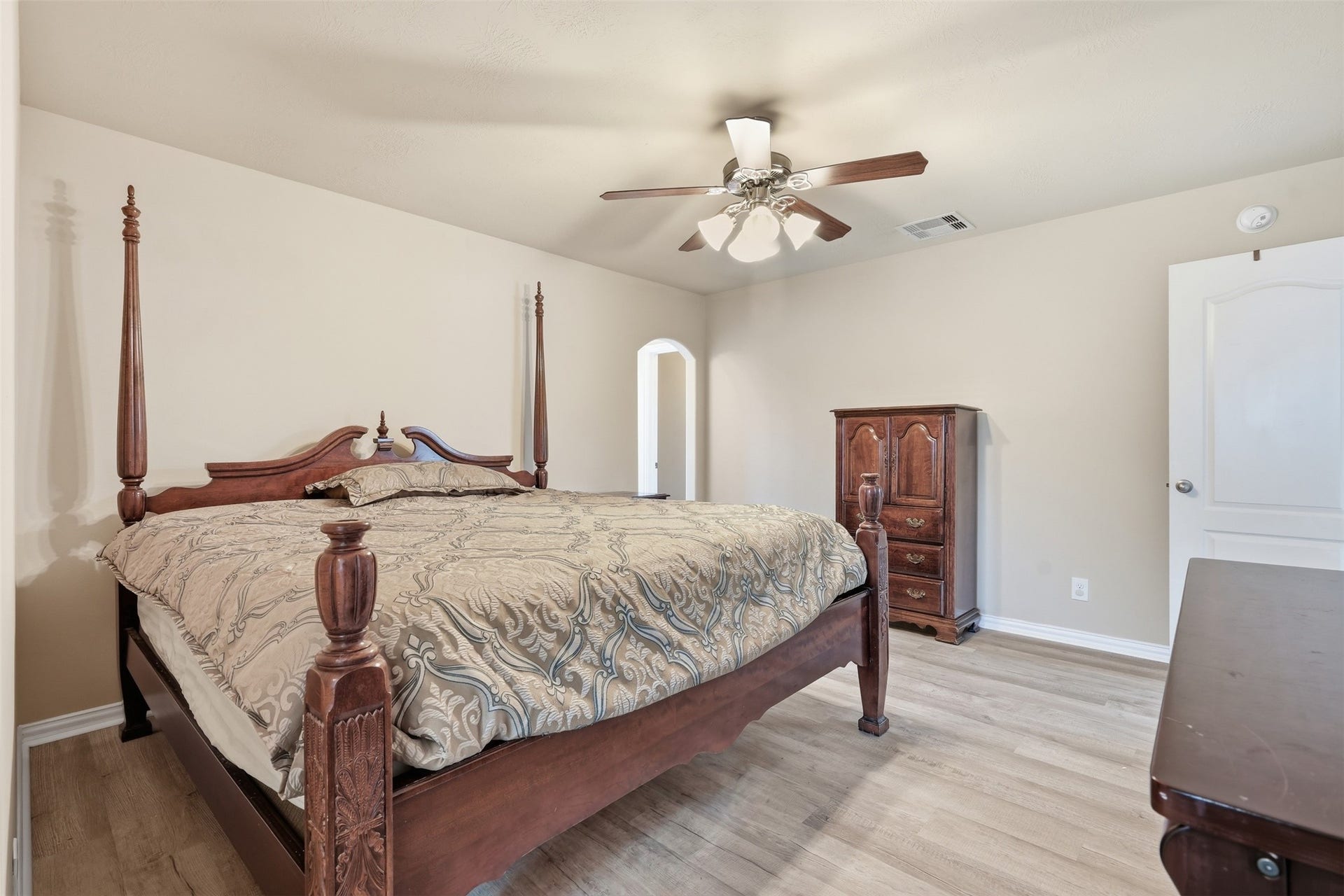 Room for a king bed and a full furniture set, plus a walk-in closet and an arched passage. This upstairs bedroom lives large.