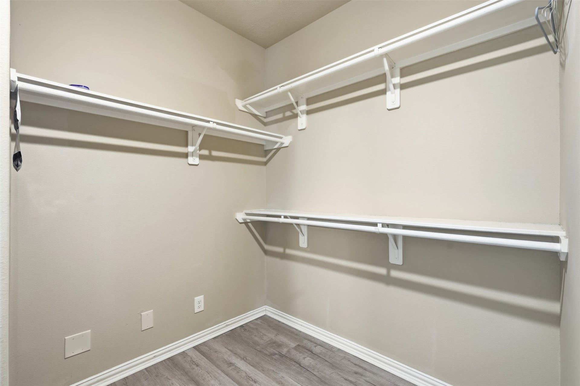 Closet space that fits a real wardrobe. The primary walk-in closet has double hanging rods and shelving on two walls, right off the primary bath.