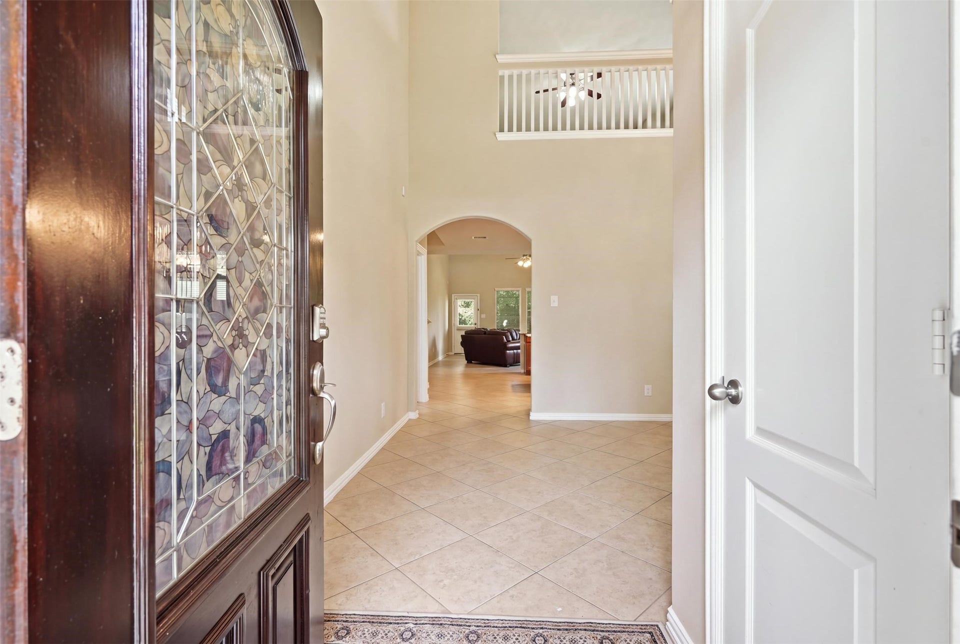 First impression: a soaring two-story foyer, a decorative leaded-glass front door, easy-care tile and an arched walkway into the heart of the home. Look up; the upstairs overlook sets the tone.
