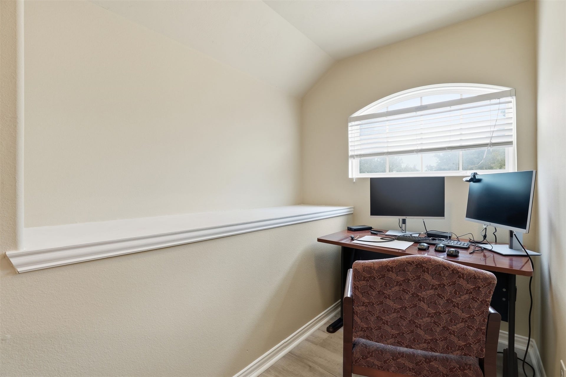 The work-from-home corner you've been hunting for: a vaulted ceiling, arched-window light and a display ledge, tucked into the upstairs bedroom.