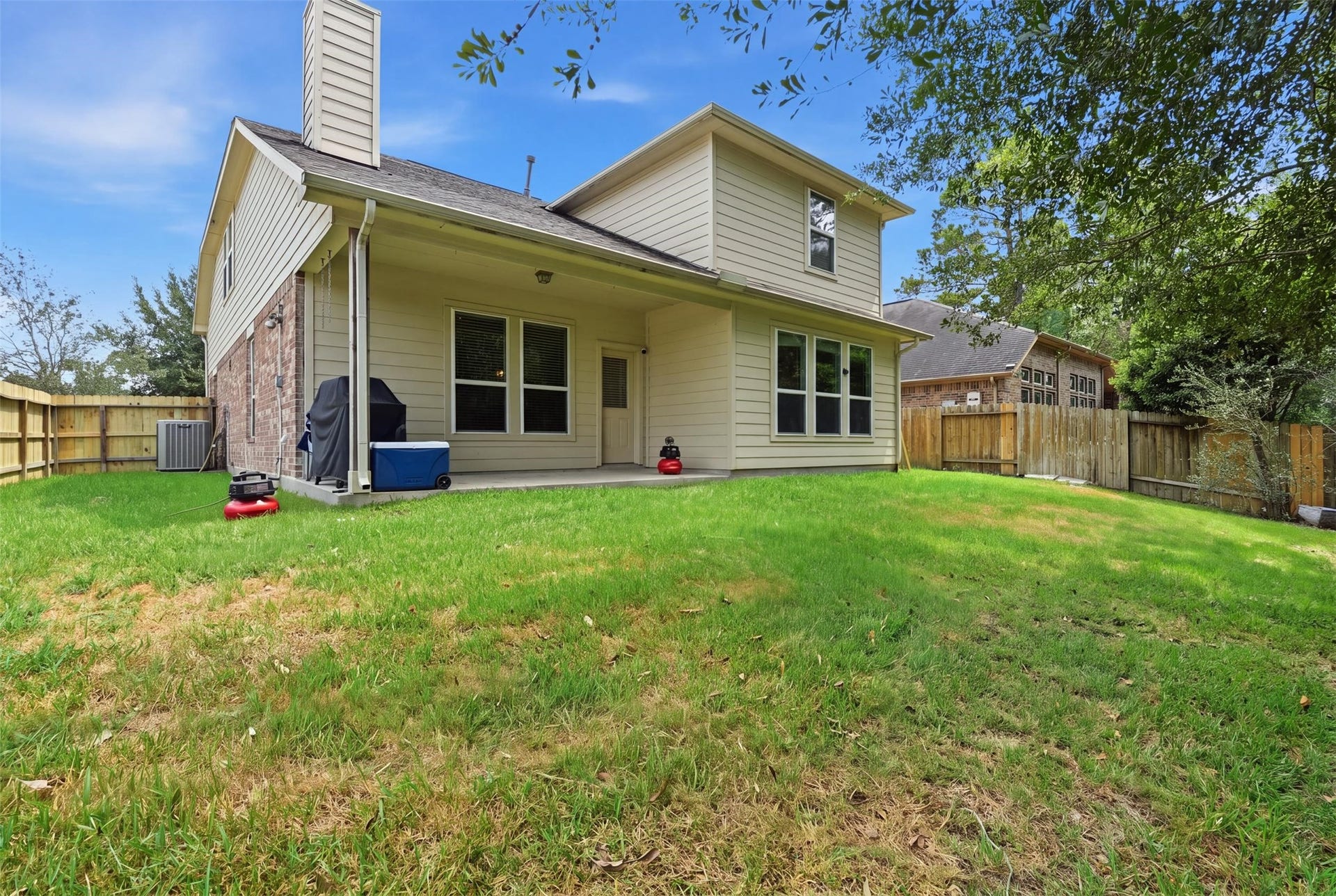 Your backyard escape: a covered patio, a fully fenced yard and room to grill, garden and unwind, with green space just beyond the fence.