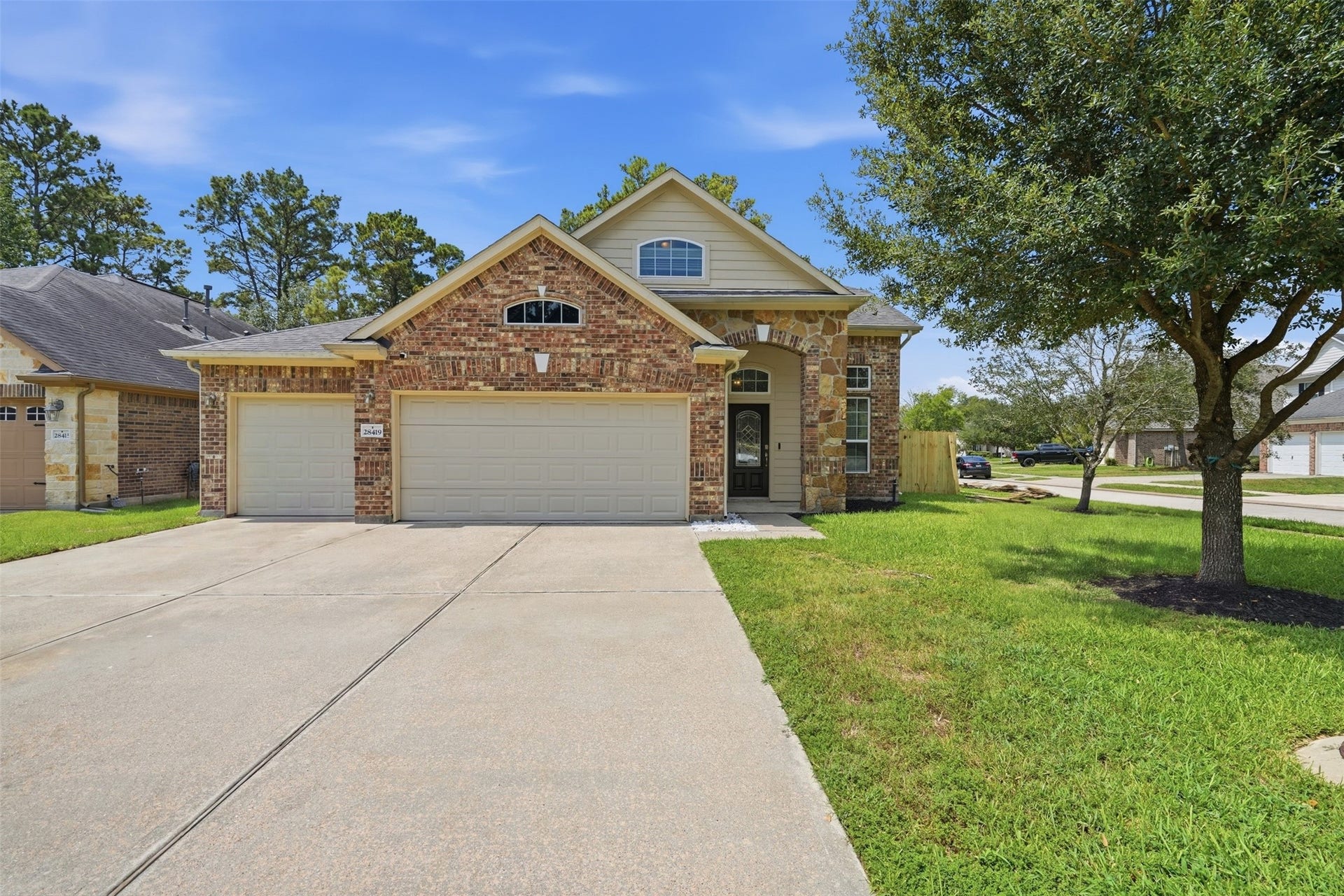 Curb appeal that stops traffic. Brick-and-stone elevation, arched stone entry, a rare 3-car garage and an extra-wide driveway, all on a quiet cul-de-sac street under mature shade.