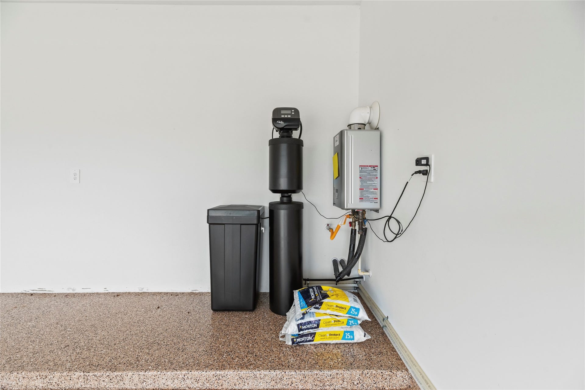 2815 Magnolia Blossom Lane, Rosenberg, TX 77469 Whole-home water softener system paired with an energy-efficient tankless water heater, helping reduce mineral buildup while providing consistent water quality and endless hot water throughout the home. The garage also features durable epoxy flooring, offering a clean, finished look thats easy to maintain.