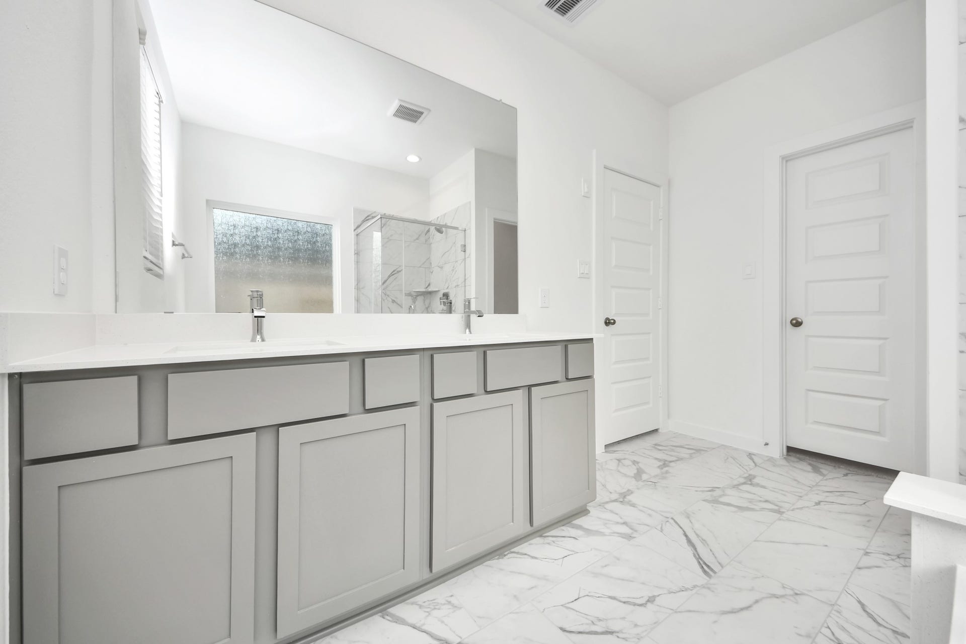 Elevate your daily routine at the elegant vanity, now equipped with double sinks, light countertops, modern hardware, and beautiful recessed lights. Sample photo of completed home with similar floor plan. Actual colors and selections may vary.