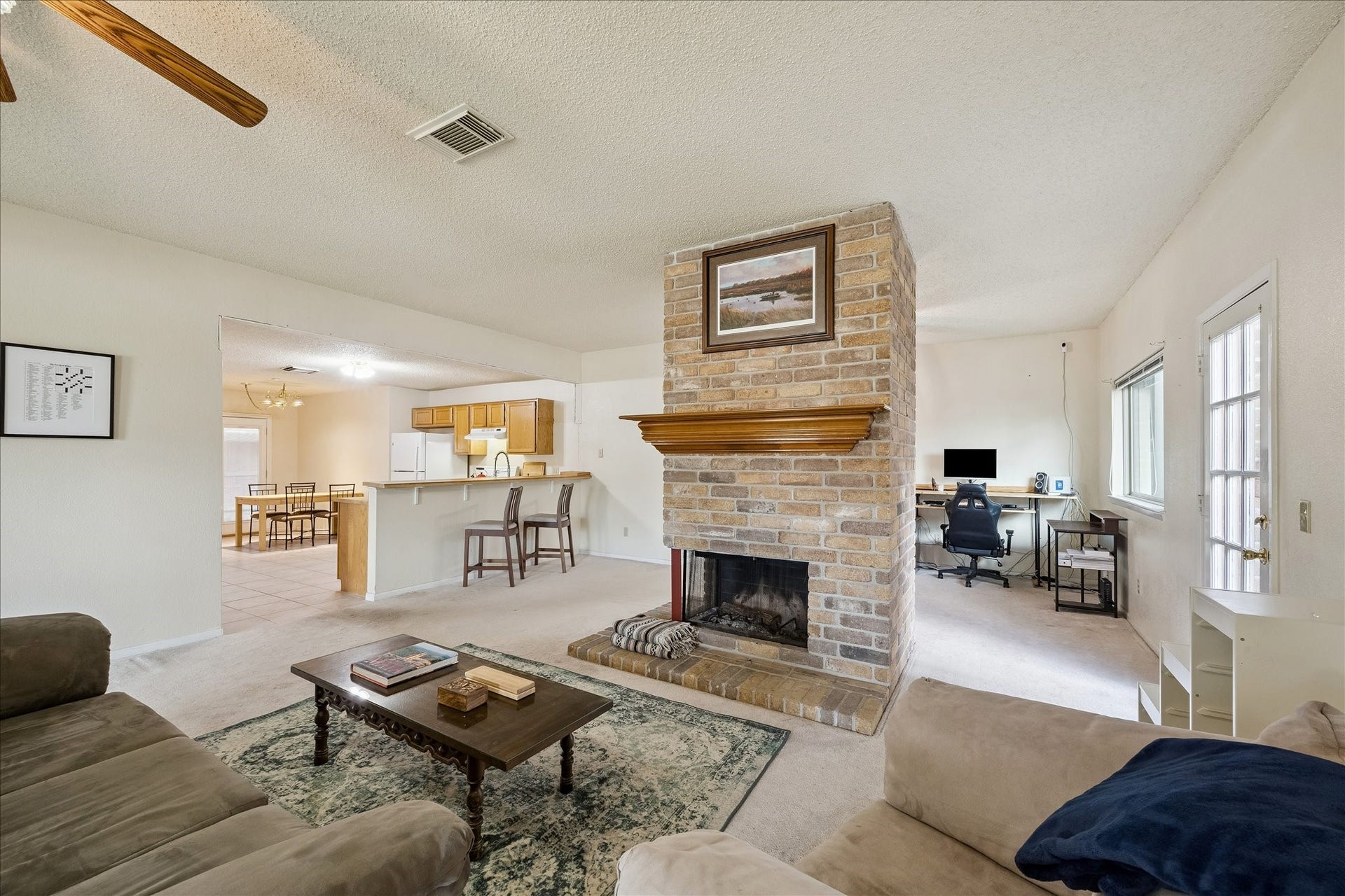 First floor living!  The large open space  is divided by a wonderful brick wood burning fireplace.  Room for a living room and dining room on either side.