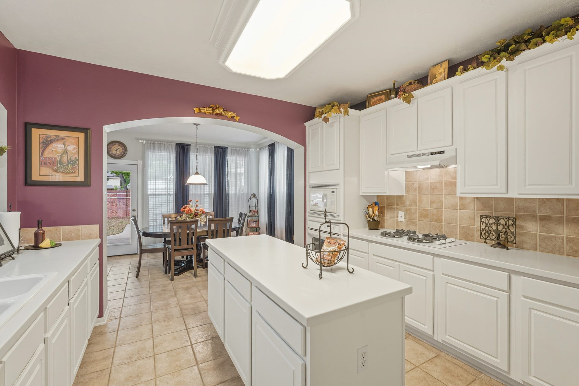 Light and Bright Island Kitchen with tile backsplash and flooring. Ton of Corian Counter space and storage.