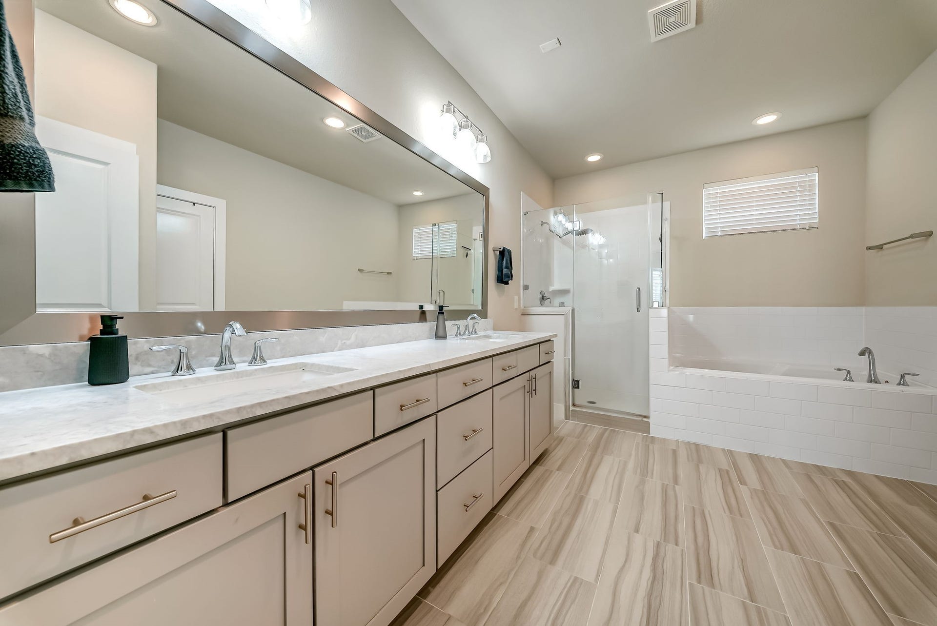 5916 Petty Street, #A, Houston, TX 77007 Spa-inspired primary bath featuring dual vanities, marble countertops, soft-close cabinetry, soaking tub, and separate shower.
