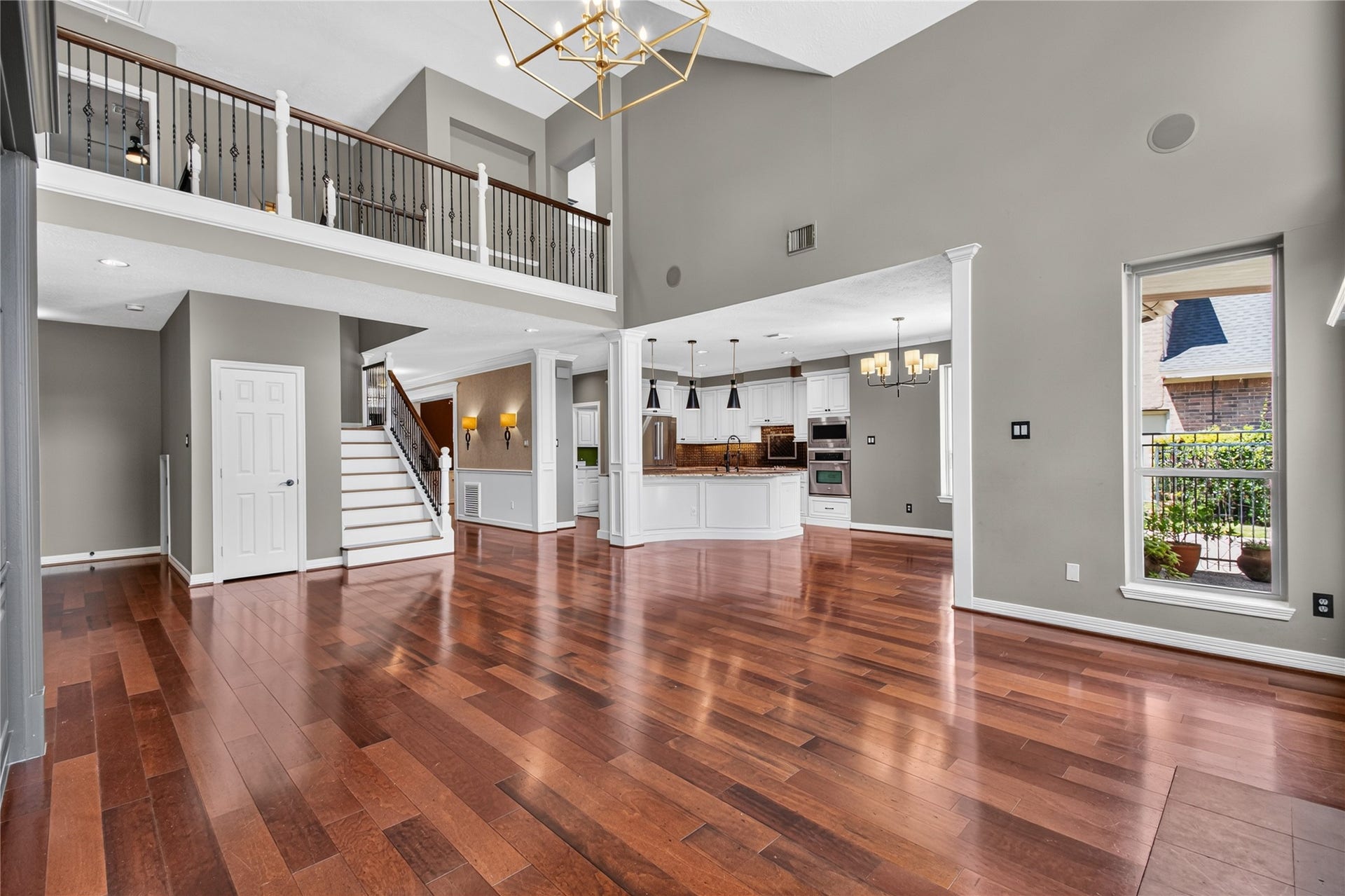 Soaring ceilings and an open layout connect the spacious family room with the kitchen and breakfast area.