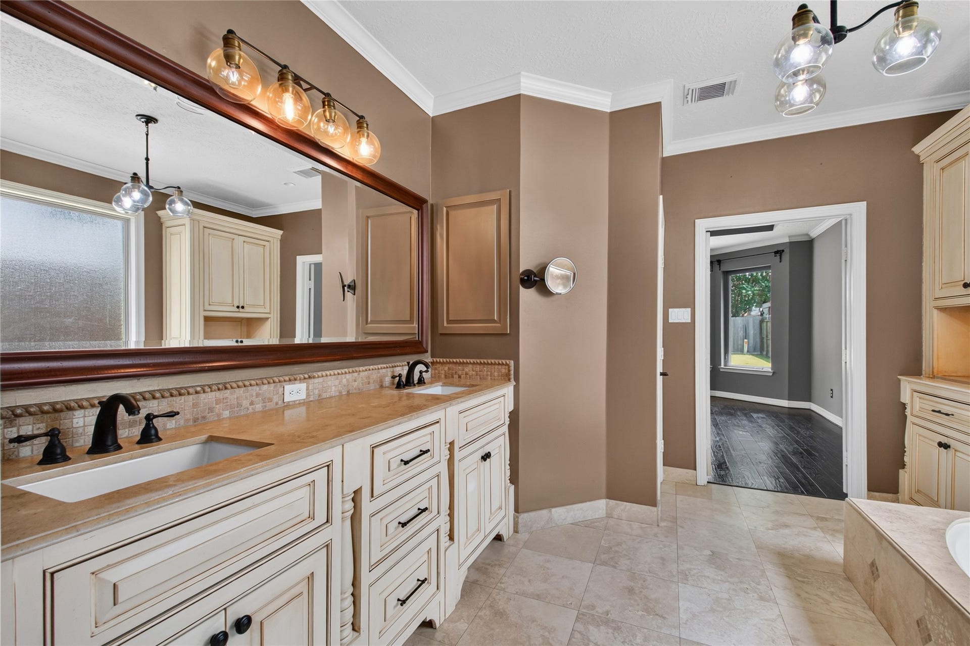 Another view of the primary bath highlights the dual vanities, abundant storage and generous getting-ready space.