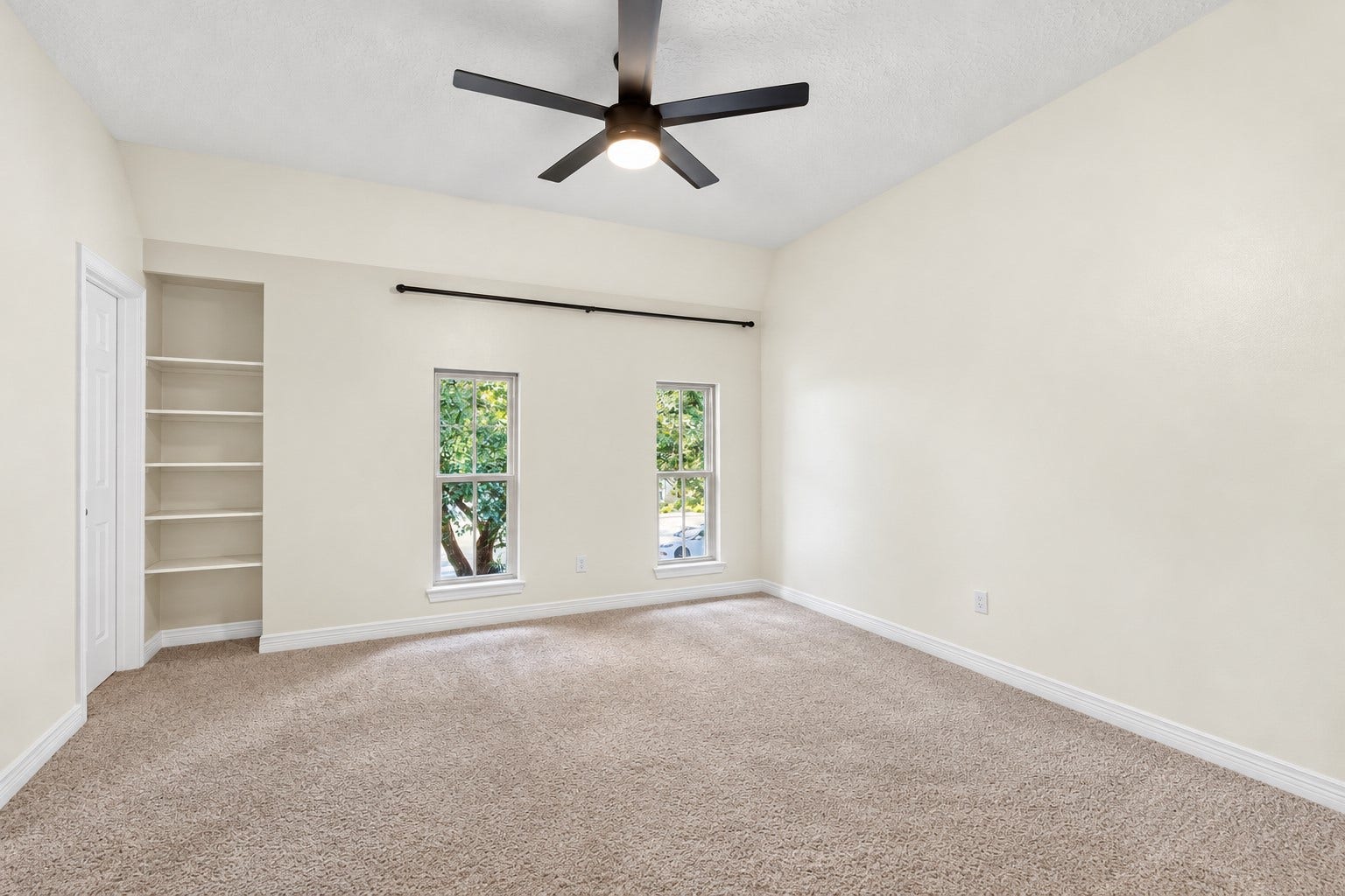 Built-in shelving adds useful storage and character to this spacious upstairs bedroom.