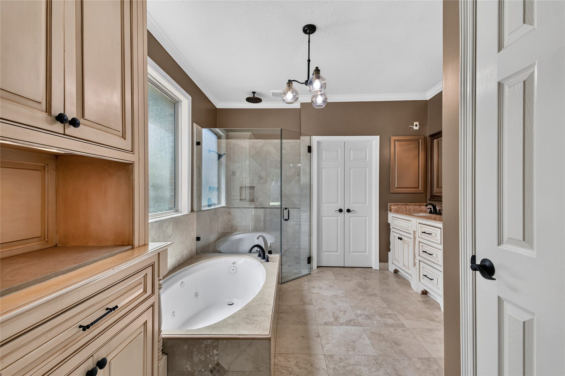 Primary bath features dual vanities, generous cabinetry, soaking tub and separate walk-in shower.