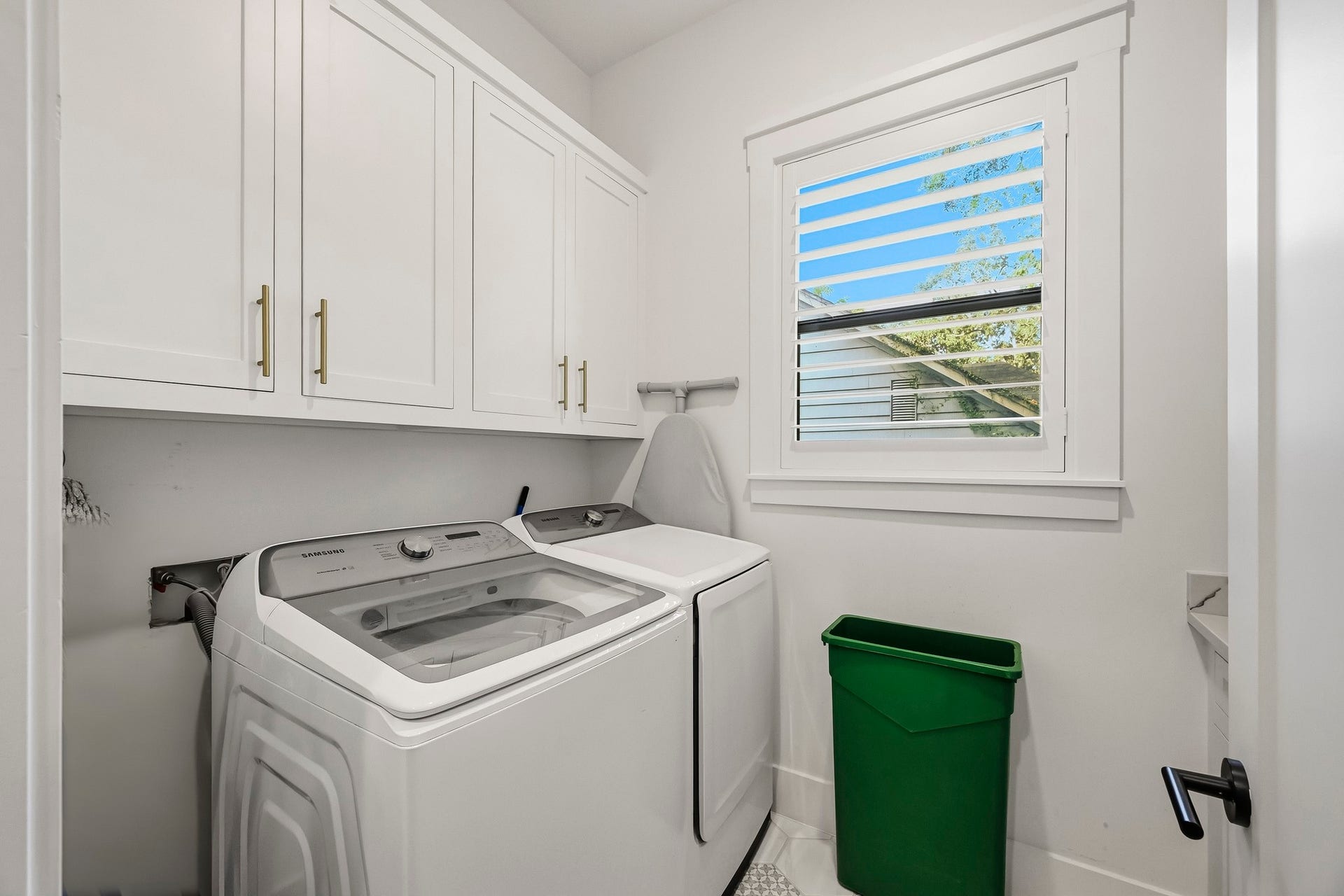 Laundry room with additional cabinet storage and shelving.