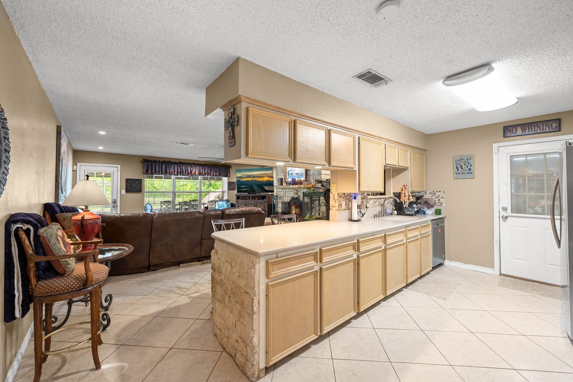 15602 Fir Road, Santa Fe, TX 77517 Spacious open-concept kitchen featuring extensive cabinetry, expansive counter space, and seamless flow into the living area. The functional layout, tile flooring, and breakfast bar design make this space ideal for both everyday living and entertaining.