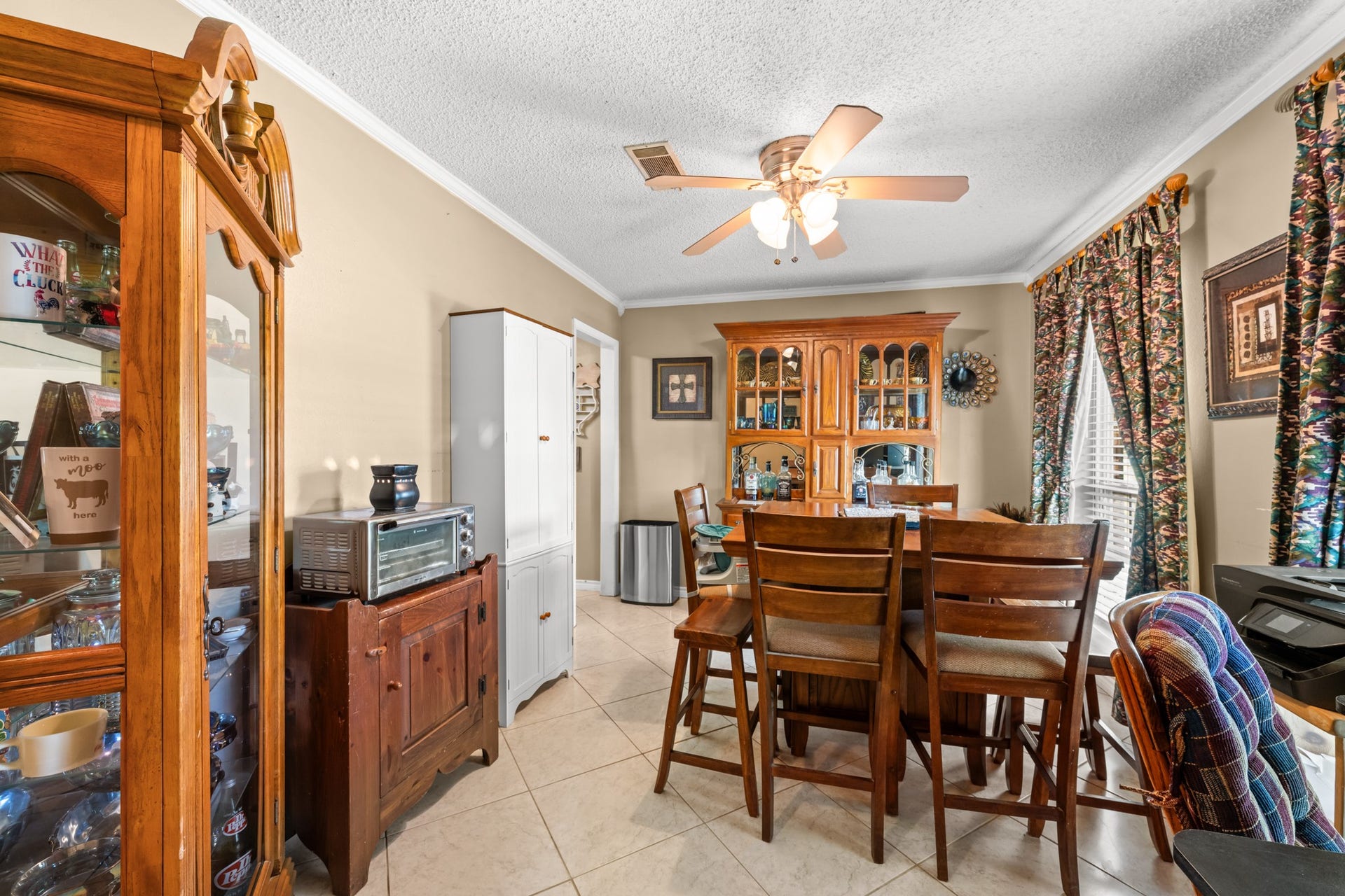 15602 Fir Road, Santa Fe, TX 77517 Spacious dining area with tile flooring, crown molding, and large windows that bring in abundant natural light. A functional layout offers plenty of room for everyday meals or hosting family gatherings.