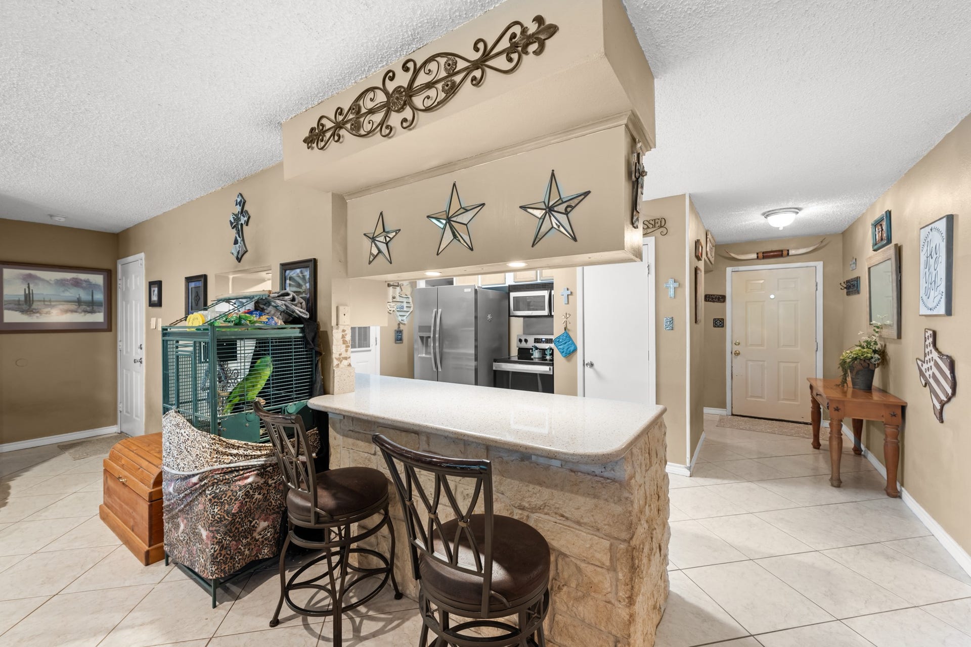 15602 Fir Road, Santa Fe, TX 77517 Spacious breakfast bar with stone accents and seating overlooks the open-concept living and kitchen areas, creating a welcoming space for casual dining and conversation. Ample counter space and an easy-flow layout enhance both functionality and entertaining potential.