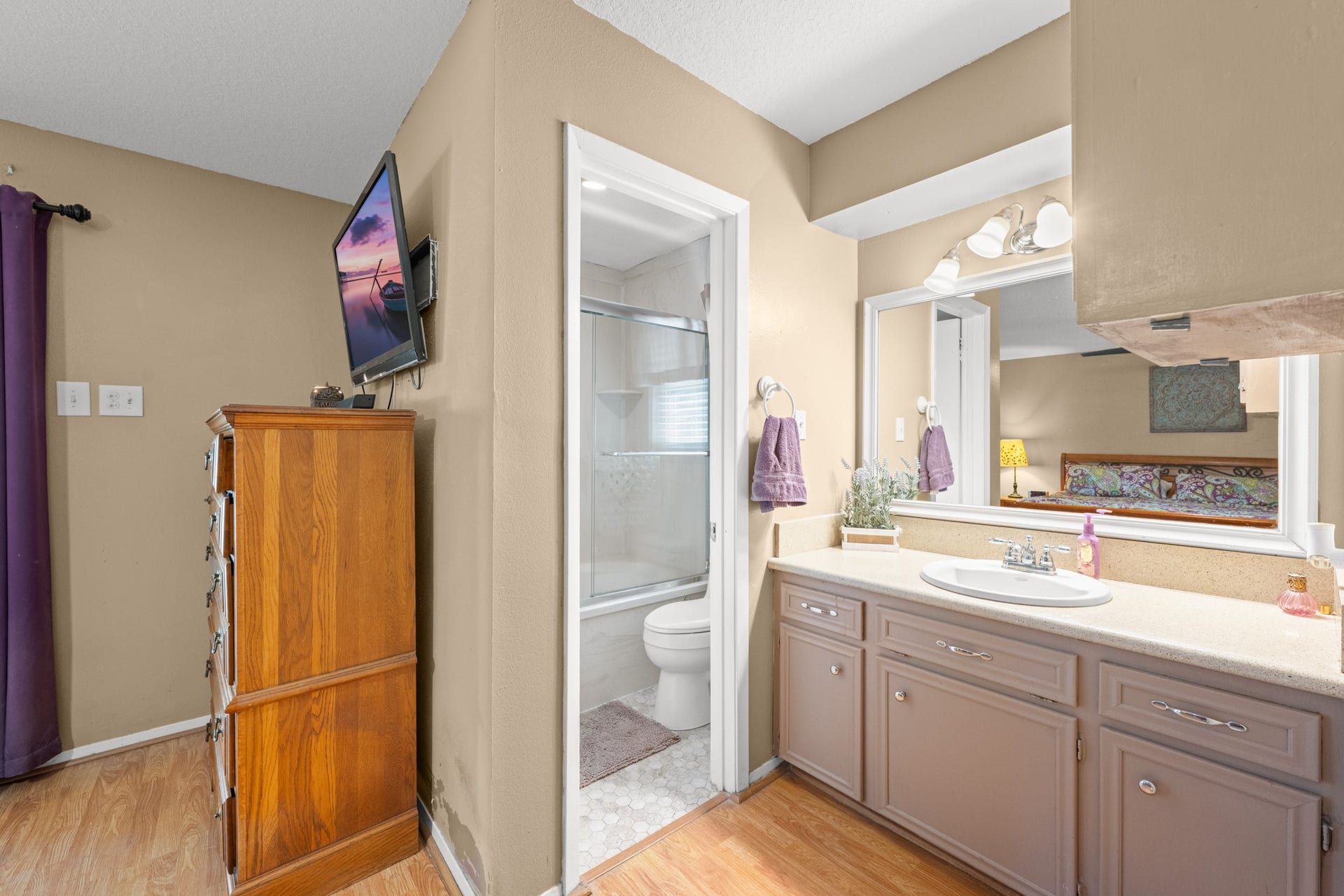 15602 Fir Road, Santa Fe, TX 77517 Spacious primary bath vanity area featuring generous counter space, ample cabinetry, and a large mirror with updated lighting. The functional layout offers convenient access to the private bath and shower area for added comfort and privacy.
