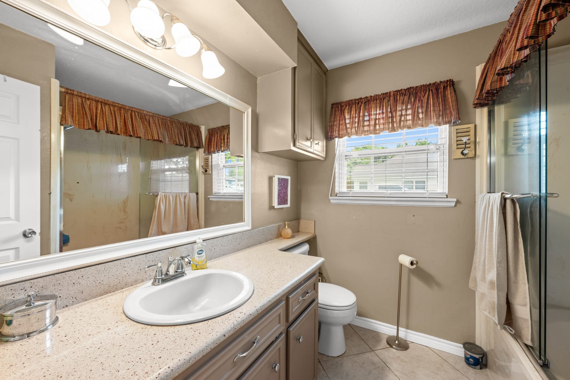 15602 Fir Road, Santa Fe, TX 77517 Well-appointed secondary bathroom featuring an oversized vanity with generous counter space, ample cabinetry, and a large mirror. Natural light and a glass-enclosed shower create a bright and functional everyday space.