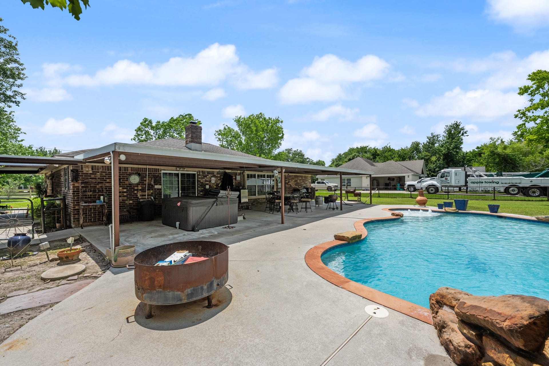 15602 Fir Road, Santa Fe, TX 77517 Expansive backyard retreat featuring a sparkling in-ground pool, oversized covered patio, and multiple spaces for outdoor dining and entertaining. The setup is ideal for relaxing weekends, gatherings, and enjoying the spacious yard.