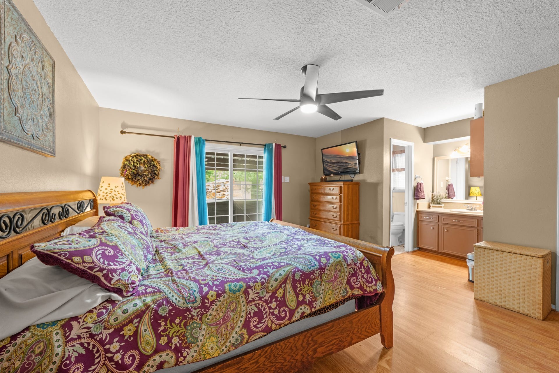 15602 Fir Road, Santa Fe, TX 77517 Spacious primary suite featuring wood-look flooring, abundant natural light, and private access to the ensuite bathroom. The generous layout and sliding glass doors create a relaxing retreat with seamless indoor-outdoor connection.
