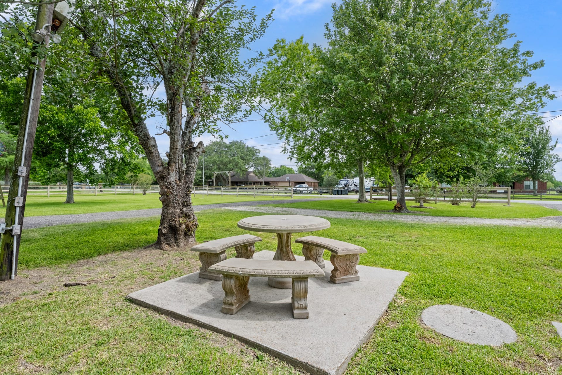 15602 Fir Road, Santa Fe, TX 77517 Peaceful outdoor seating area surrounded by mature shade trees and expansive green space, offering the perfect setting to relax and enjoy the propertys tranquil surroundings. The spacious yard provides plenty of room for outdoor activities, gardening, or entertaining.