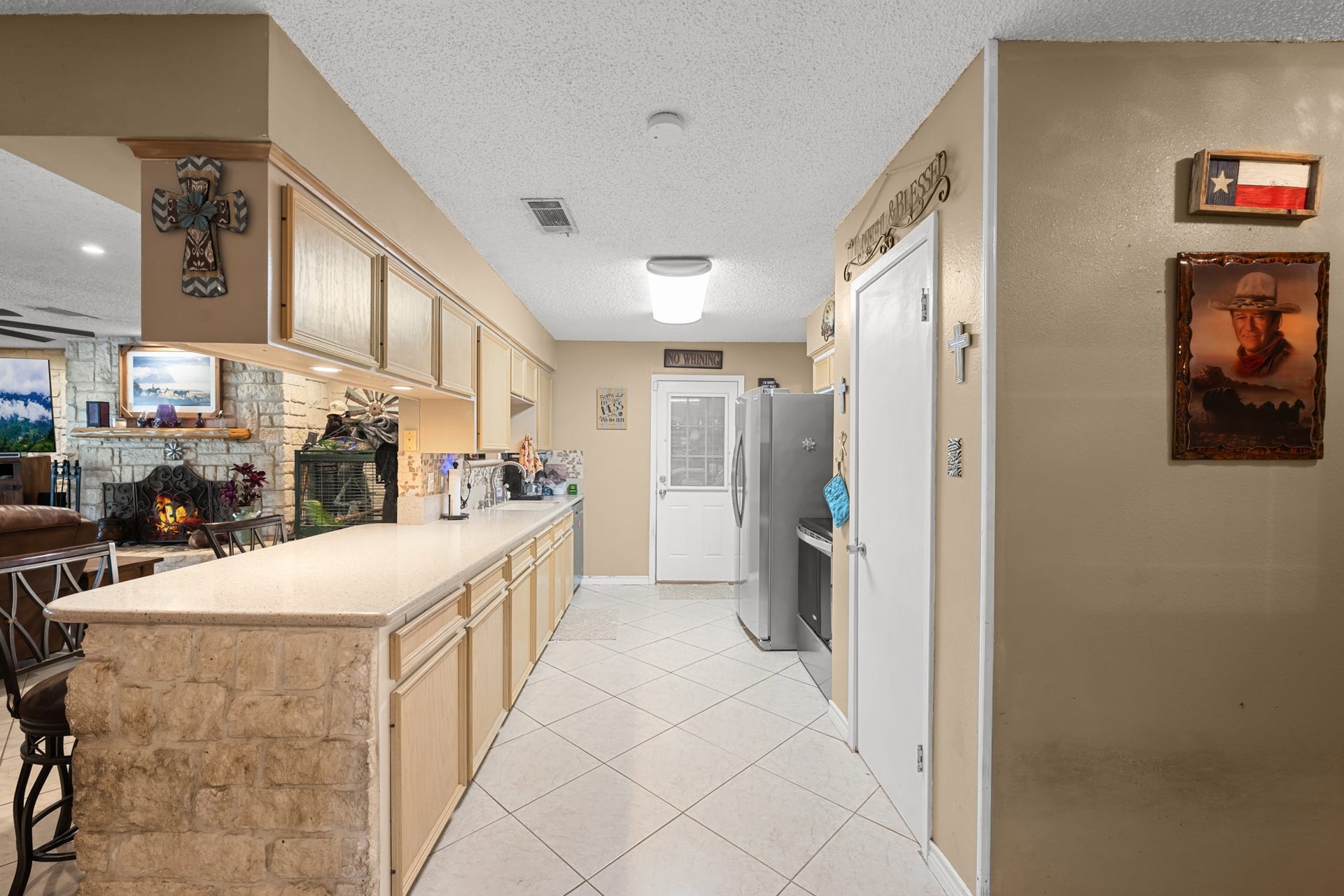 15602 Fir Road, Santa Fe, TX 77517 Bright and functional kitchen featuring abundant cabinetry, expansive countertops, and a convenient breakfast bar with stone accents. The open layout overlooks the living area, creating an ideal setup for entertaining and everyday gatherings.