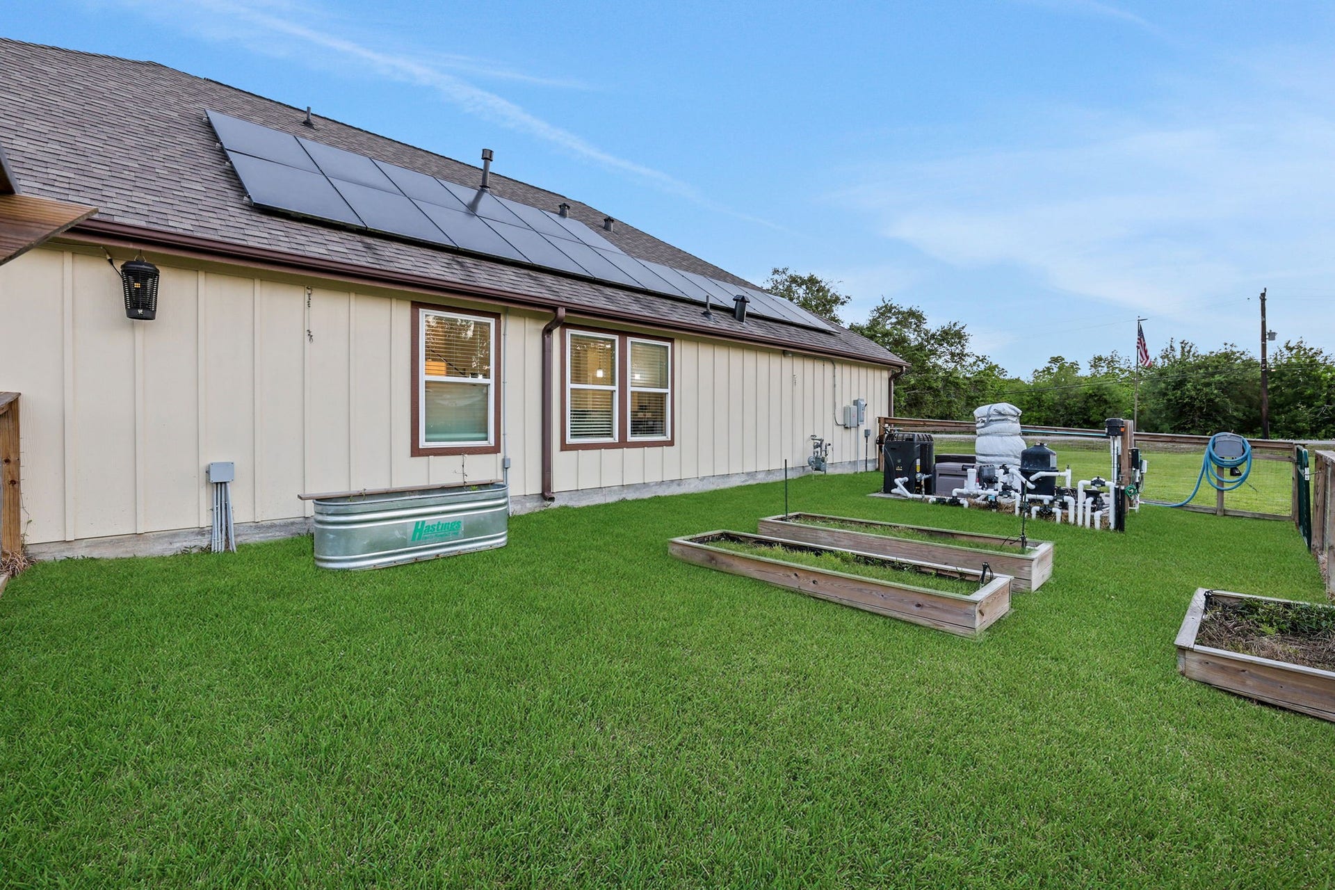 12751 County Road 283, Alvin, TX 77511 Energy-efficient home with solar panels, a spacious backyard, and raised garden beds for sustainable living.