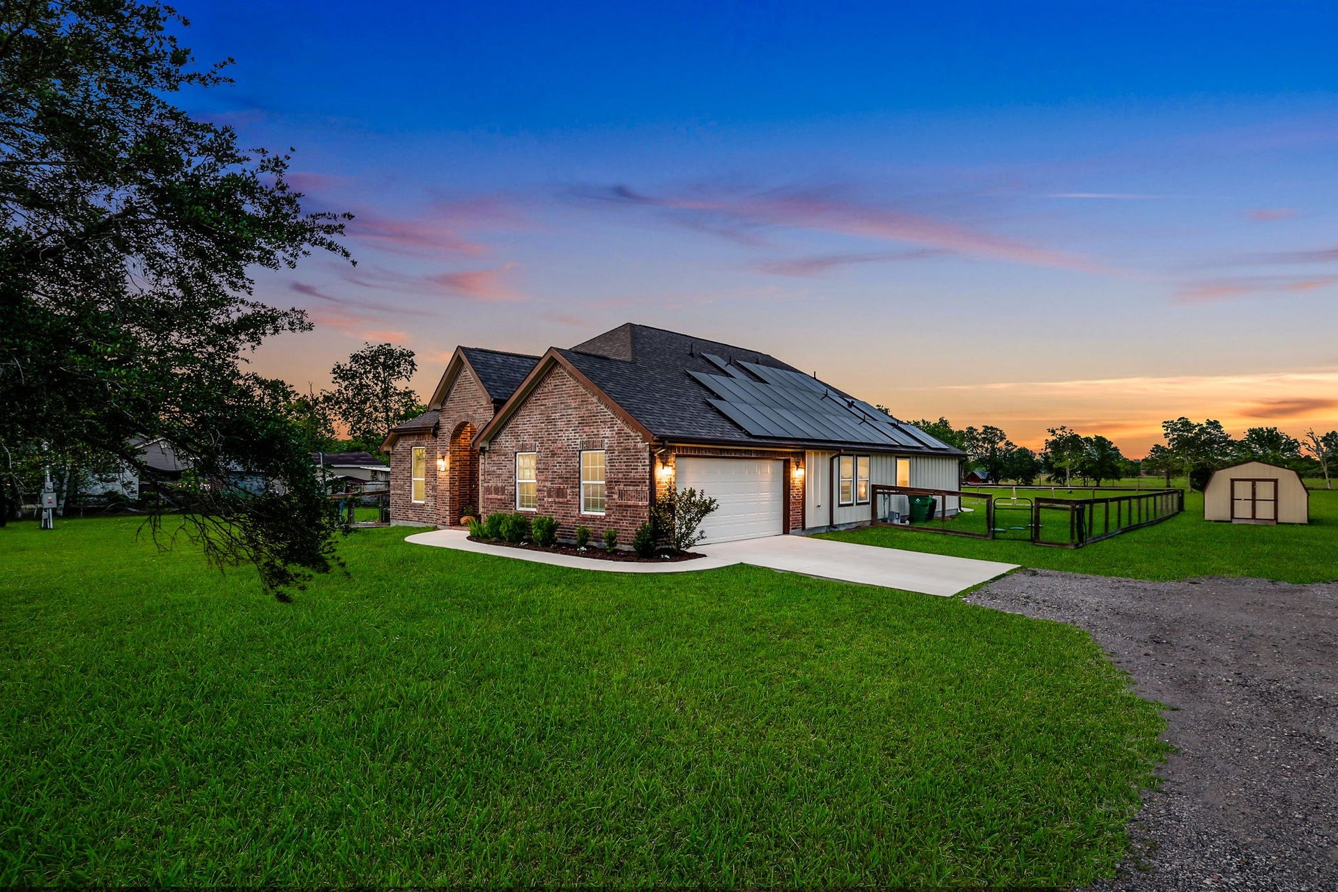 12751 County Road 283, Alvin, TX 77511 Discover a serene retreat with an expansive driveway perfect for hosting guests, nestled in a picturesque setting at sunset.