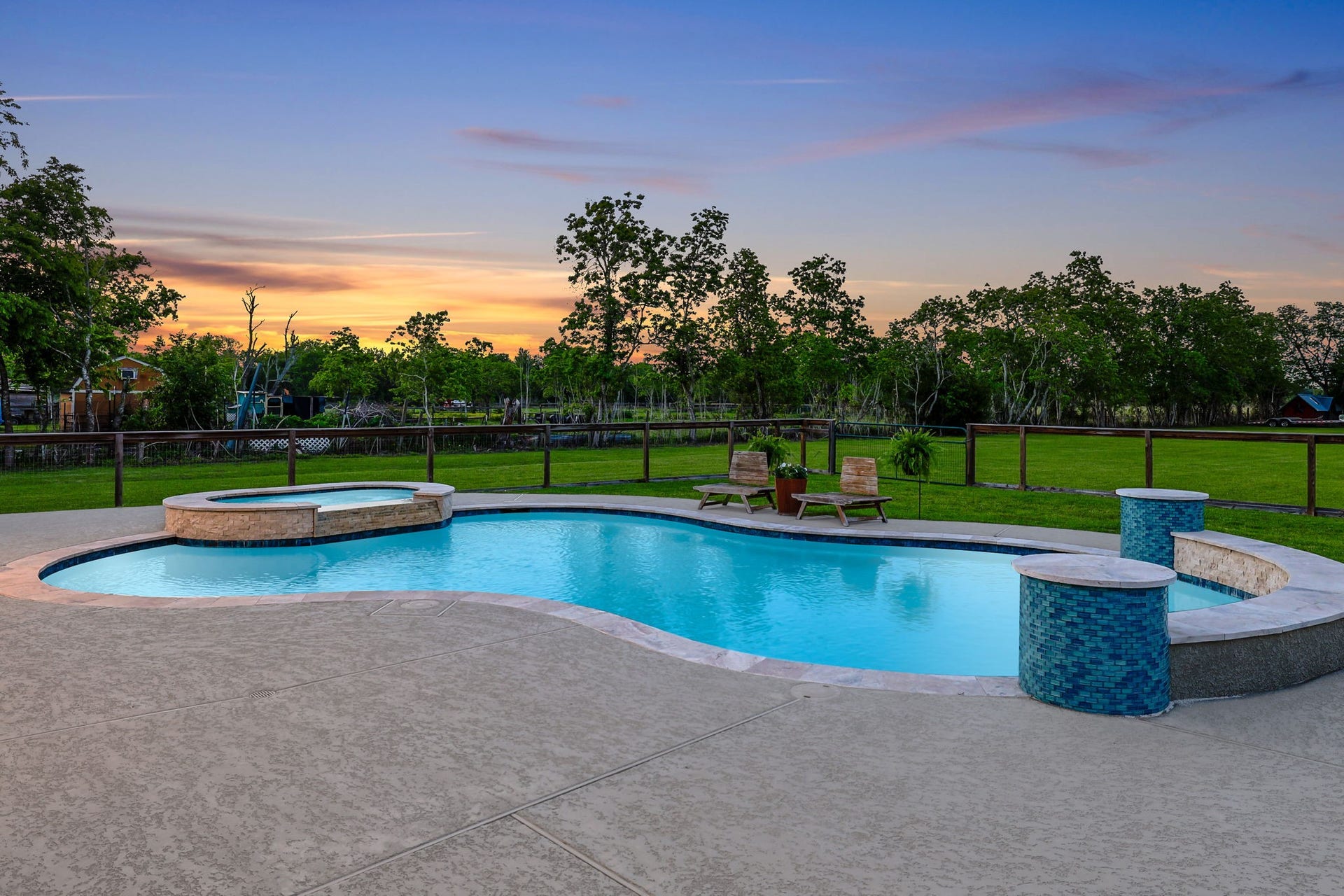 12751 County Road 283, Alvin, TX 77511 Enjoy serene sunsets by the sparkling pool and spa, surrounded by lush greenery and expansive views, perfect for relaxation and outdoor entertaining.