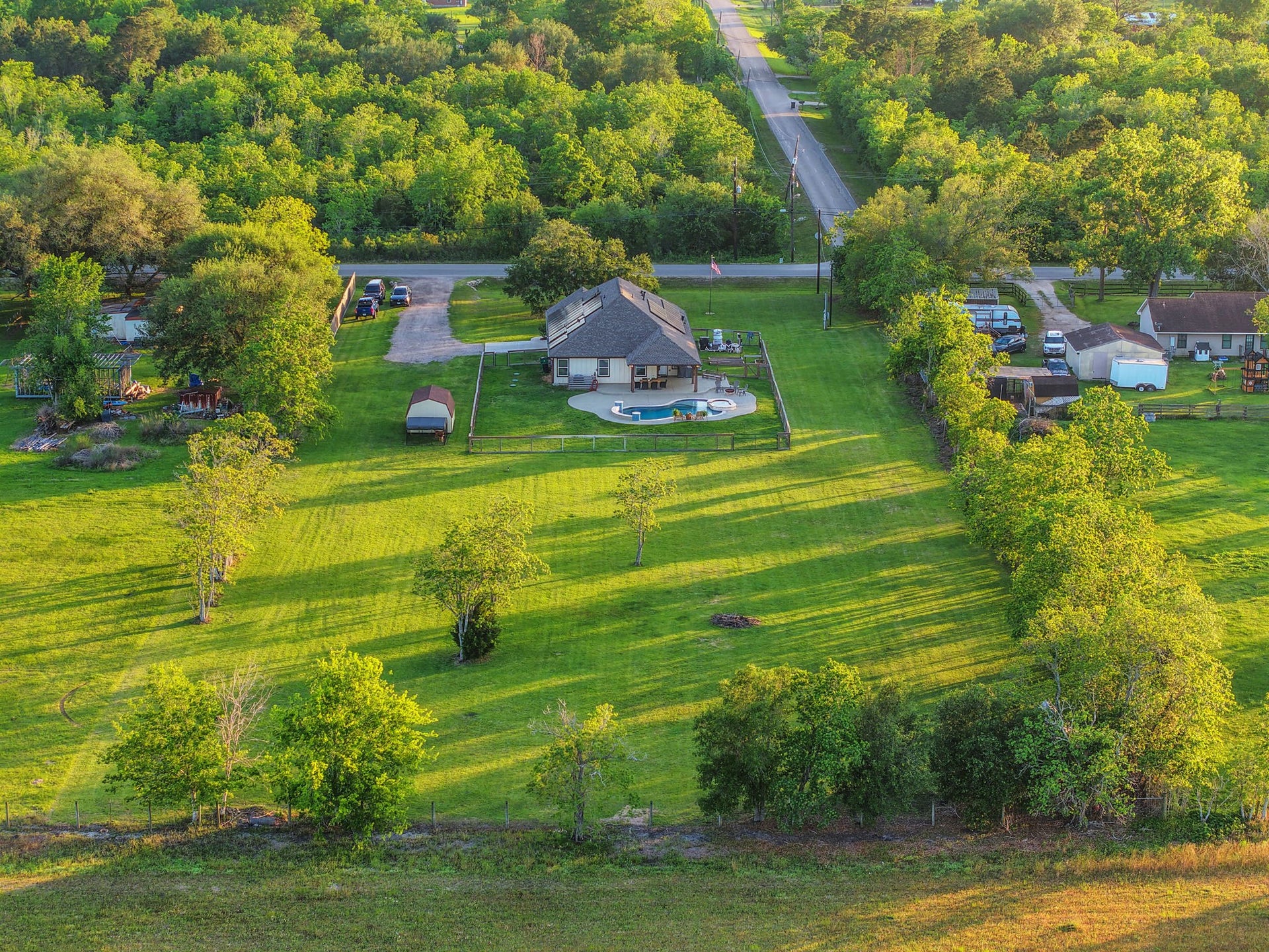 12751 County Road 283, Alvin, TX 77511 Charming home nestled in expansive greenery, featuring a private pool and spacious backyard, perfect for serene country living.