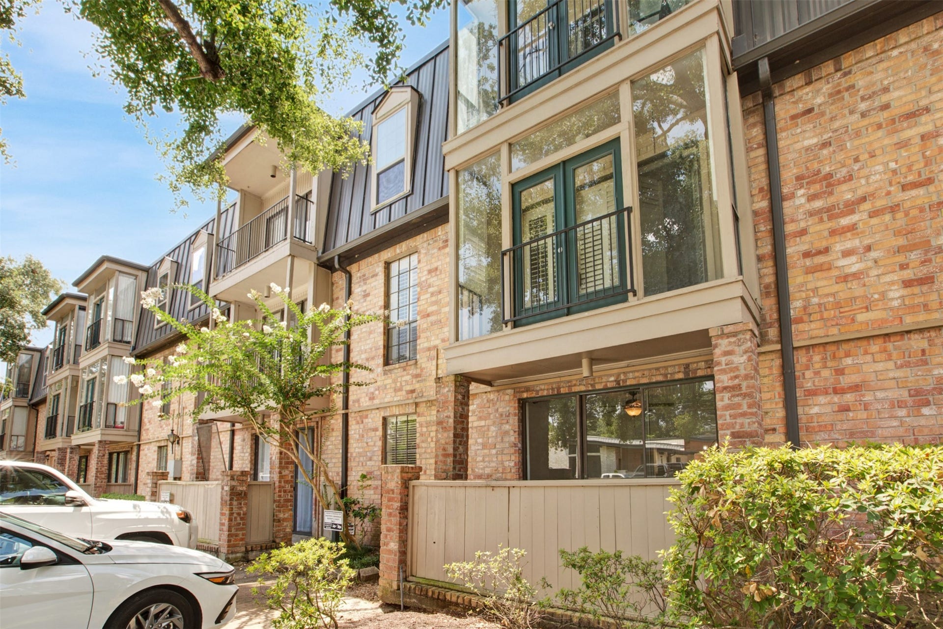 2475 Underwood Street, #180, Houston, TX 77030 Charming brick townhome with contemporary balconies and lush greenery invites you into a serene urban retreat.