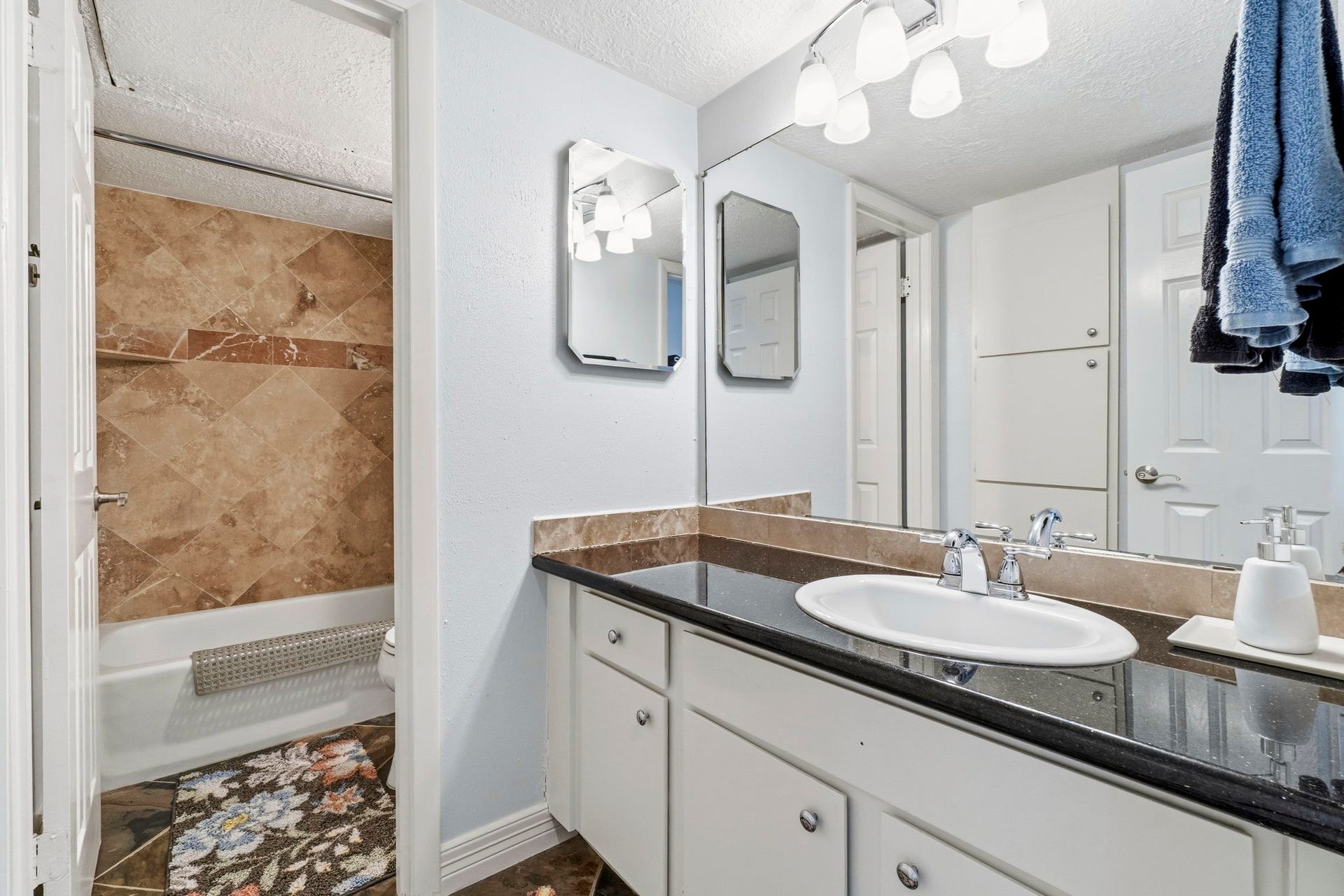 Secondary Full Bathroom Well-appointed bath with granite countertops, ample storage, and attractive finishes.