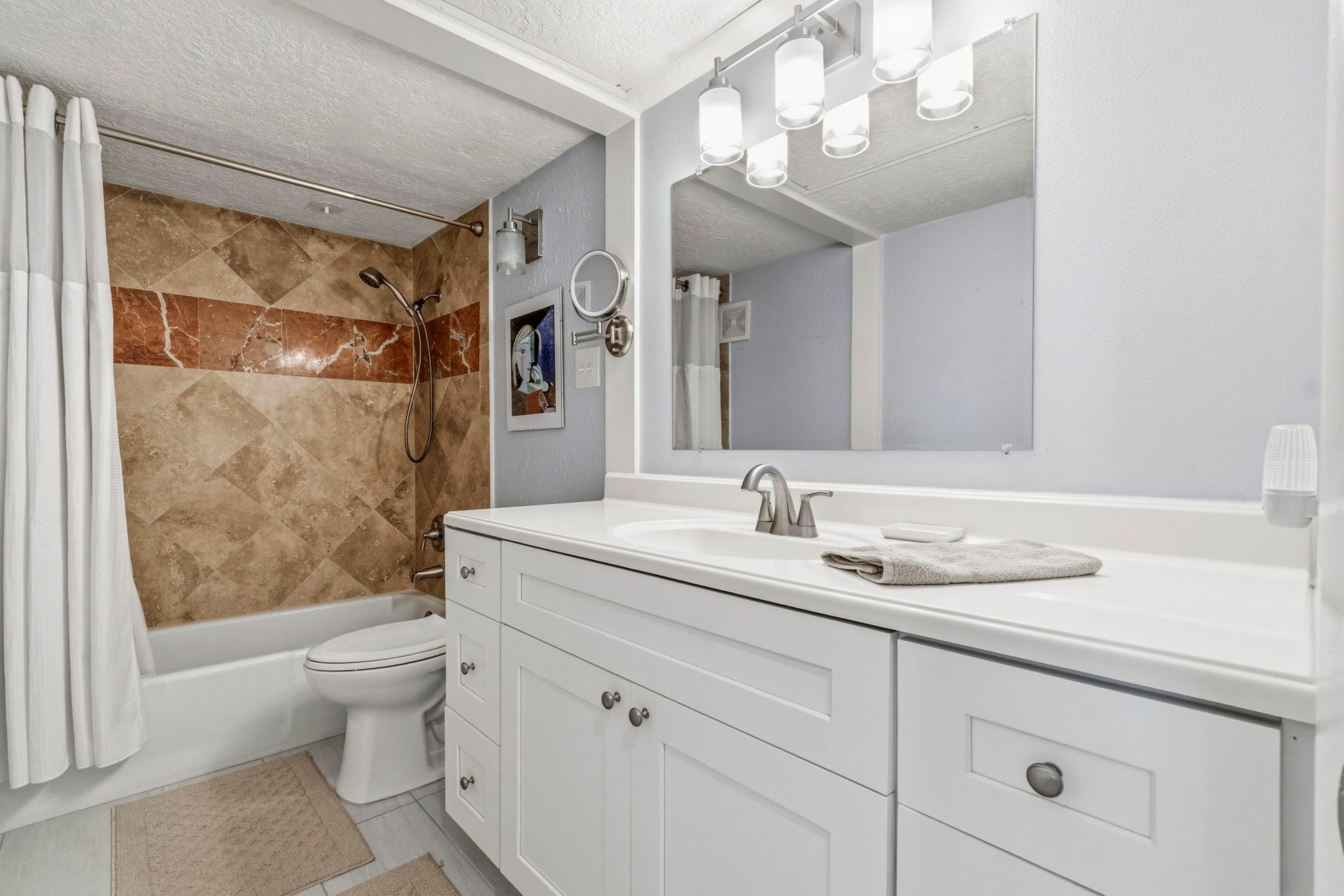 Updated Primary Bathroom Beautifully remodeled bath featuring a modern vanity, updated fixtures, and elegant tile surround.